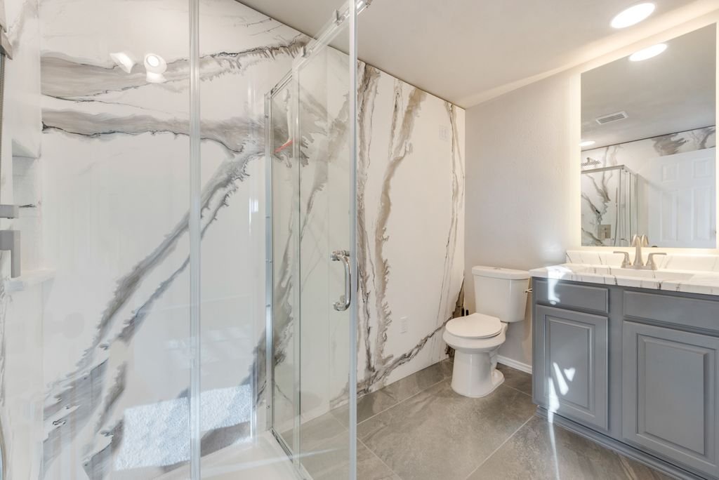 Full Bathroom: New epoxy shower walls, glass enclosure, custom vanity, mirror, integrated lighting, and an updated layout converted from an upstairs living area