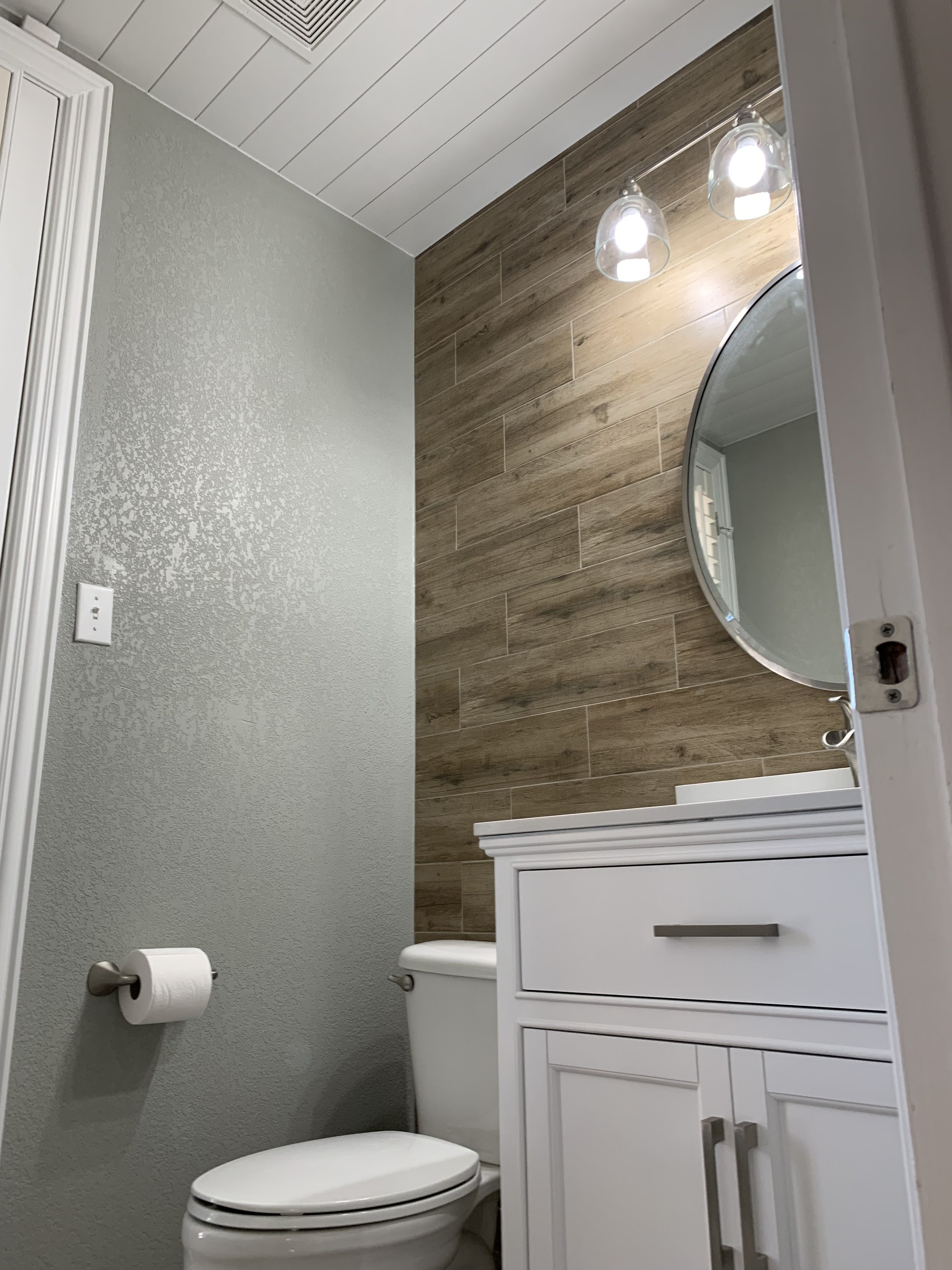 Half Bathroom: Transformation emphasized with clean lines and natural light through a new vanity, sleek mirror, and a modernized color palette 