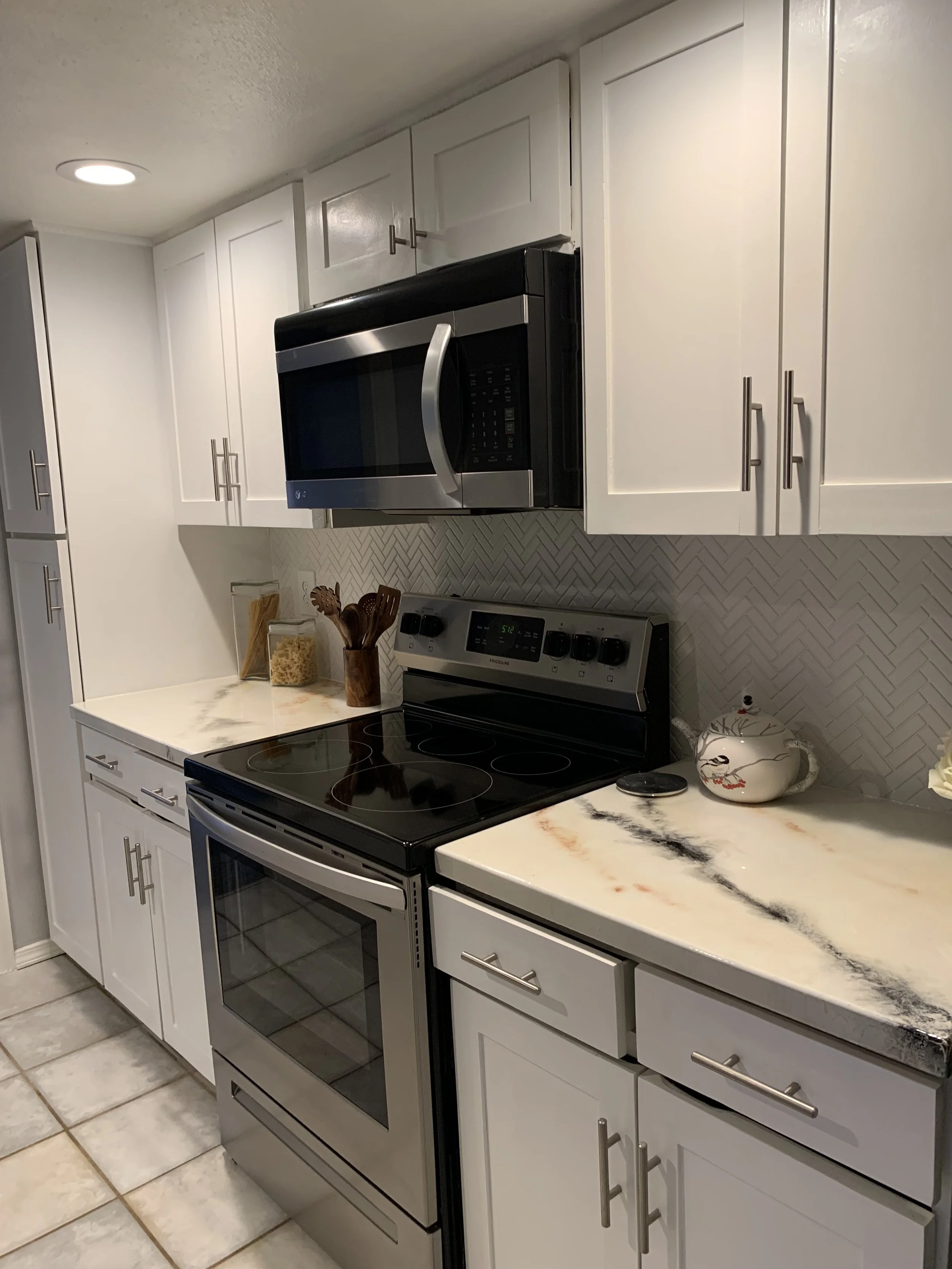 Kitchen: Existing cabinetry updated with custom 1x wood accents and integrated with modern appliances for a refined finish.
