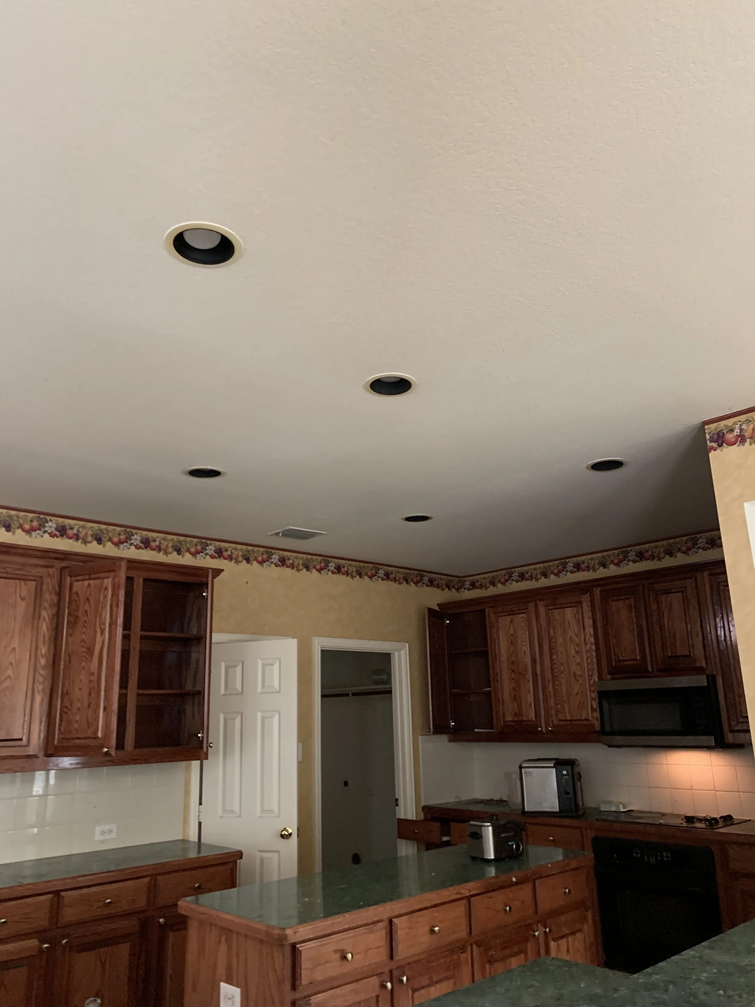 Kitchen: Dated finishes and inadequate lighting obscured the room's potential (Before)