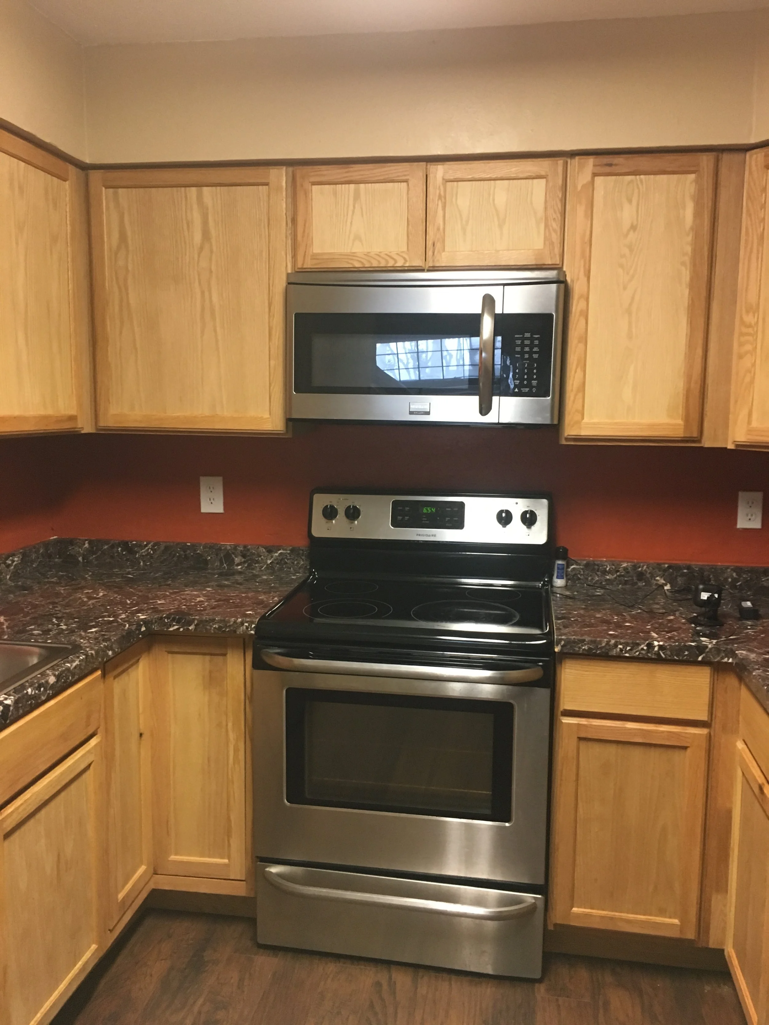 Kitchen: Original cabinetry and a harsh color palette with dated finishes (Before)