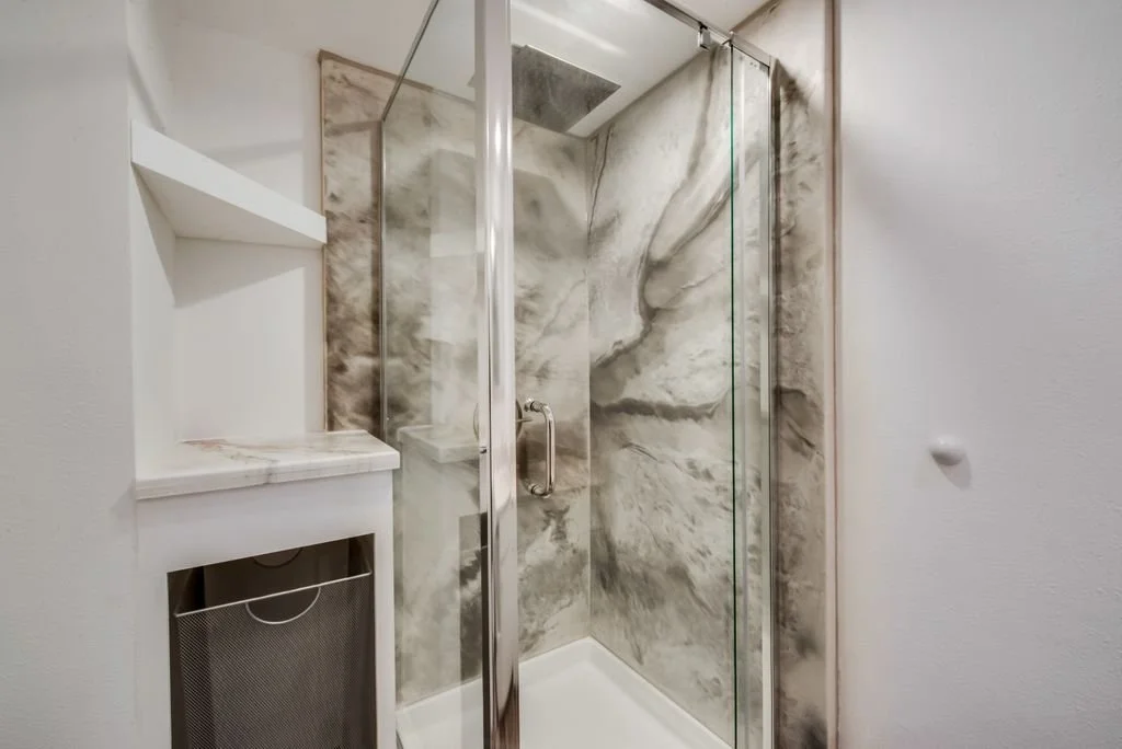Half Bathroom: Custom cabinetry and epoxy shower walls for a modern, high-durability finish