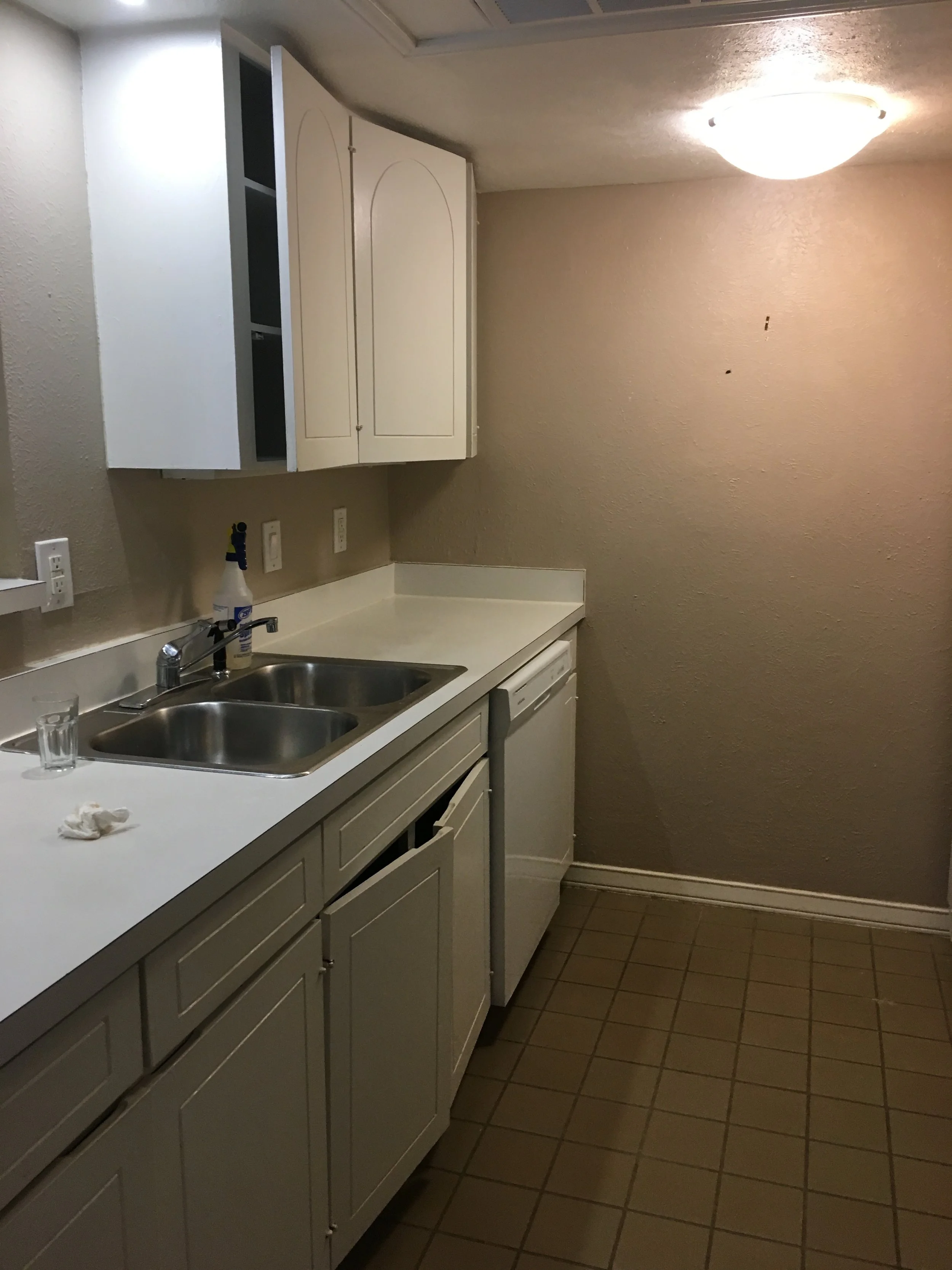 Kitchen: Dated aesthetic and inadequate lighting combined to make original space feel cramped, dark, and disconnected (Before)