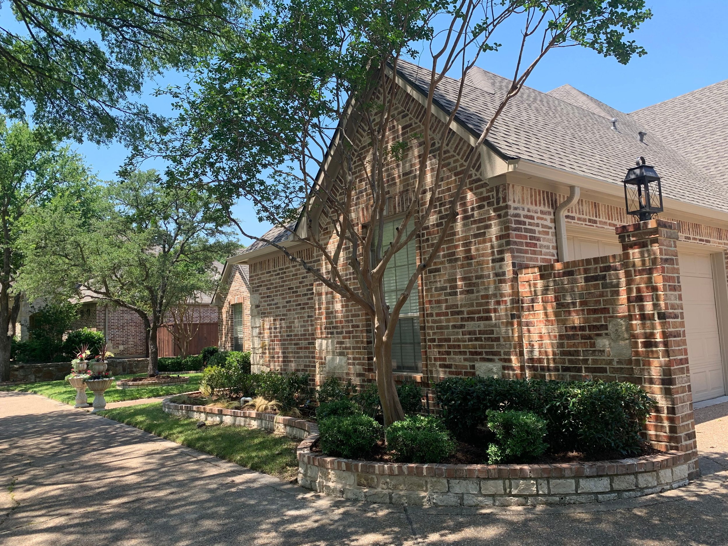 Landscape: Crape myrtles and existing shrubs trimmed with mulch installation provides the quick transformation for the front yard