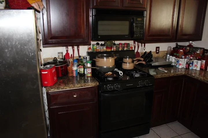 Kitchen: Original dark cabinetry and heavy finishes that constrained the visual space (Before)