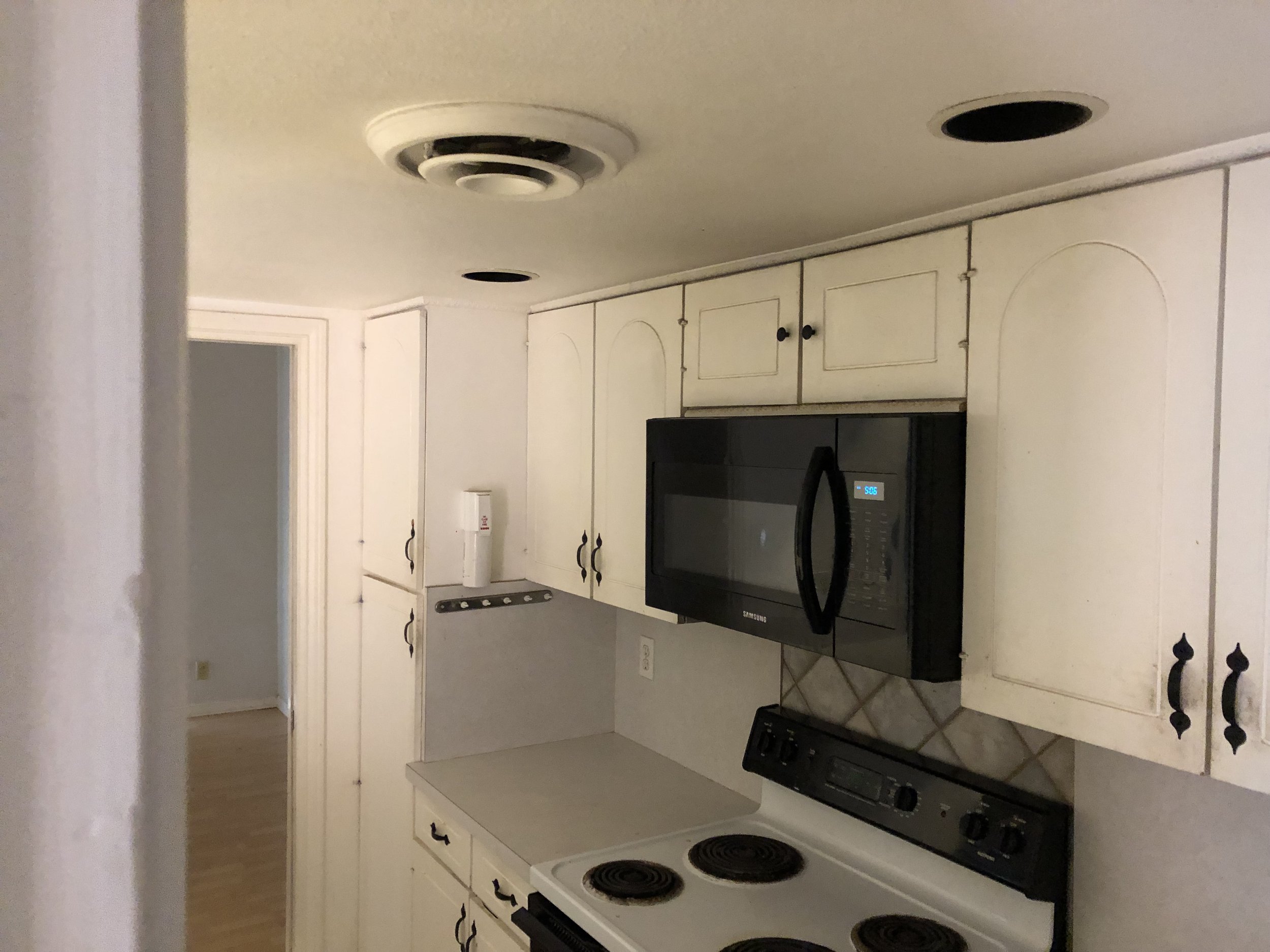 Kitchen: Dated original cabinetry and finishes (Before)