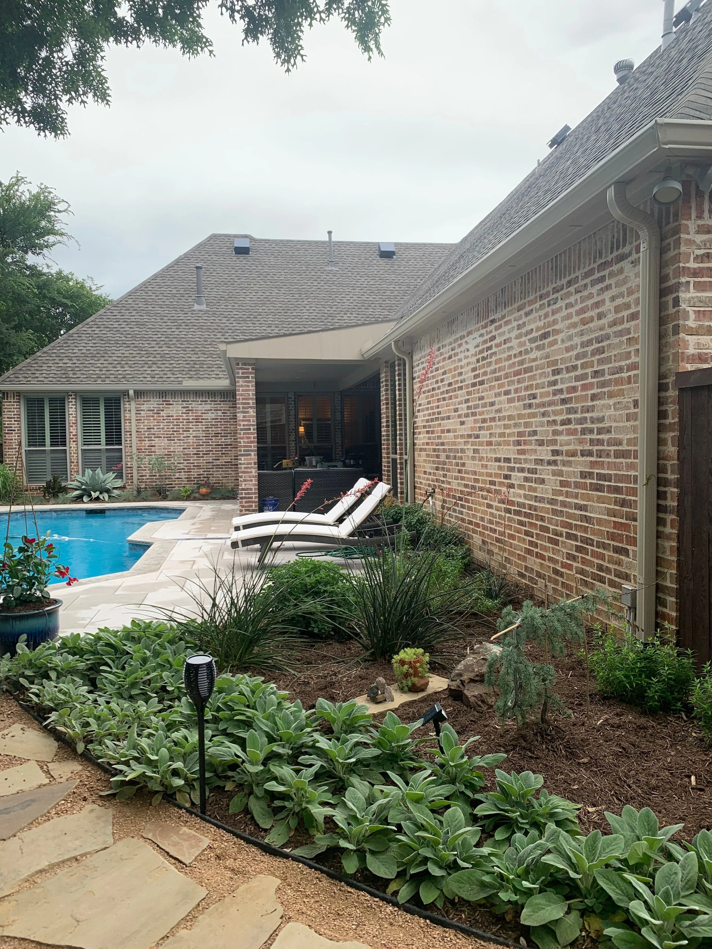 Landscape: New flagstone pavers, mulch installation, integrated path lighting provided by client, additional perennial plants