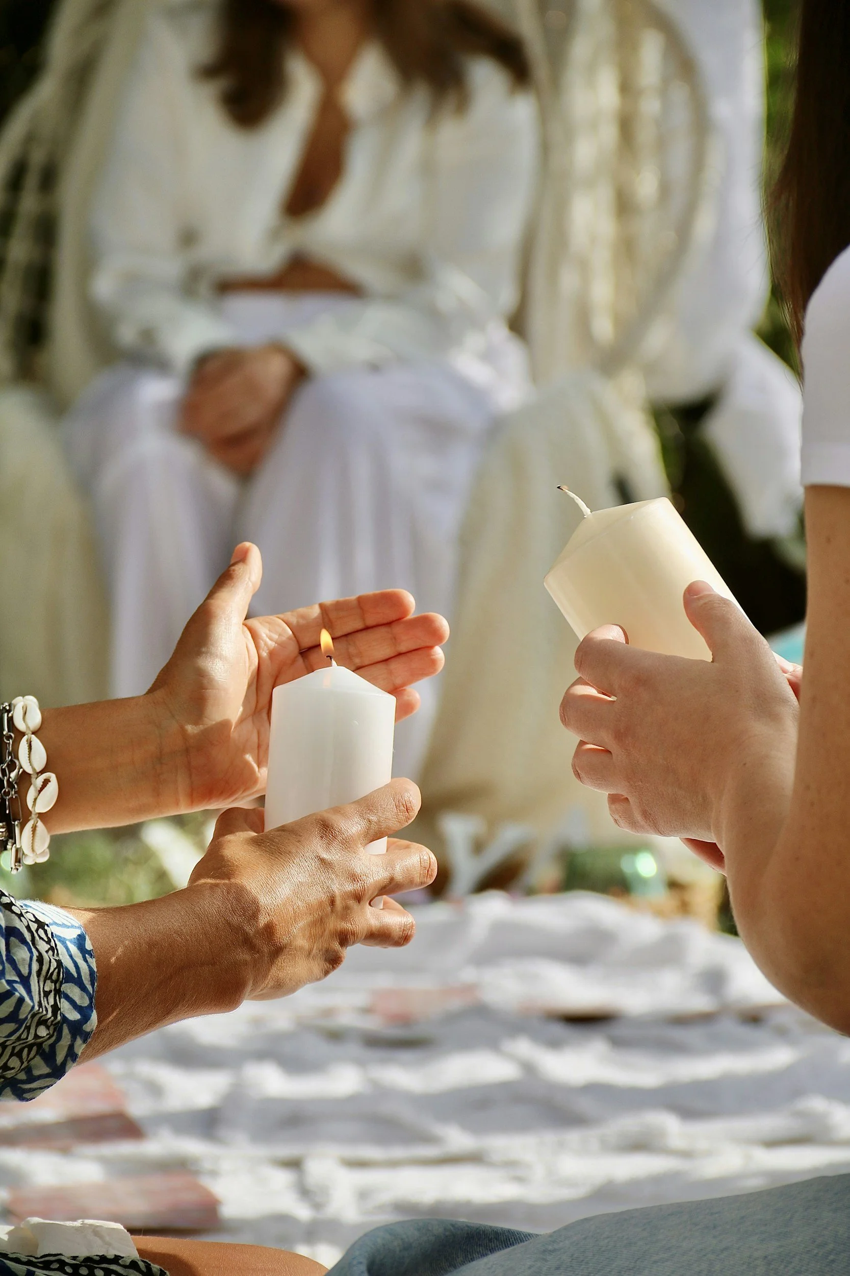 women gathering together in a mother blessing ceremony or blessingway. They are holding candles and lighting them together