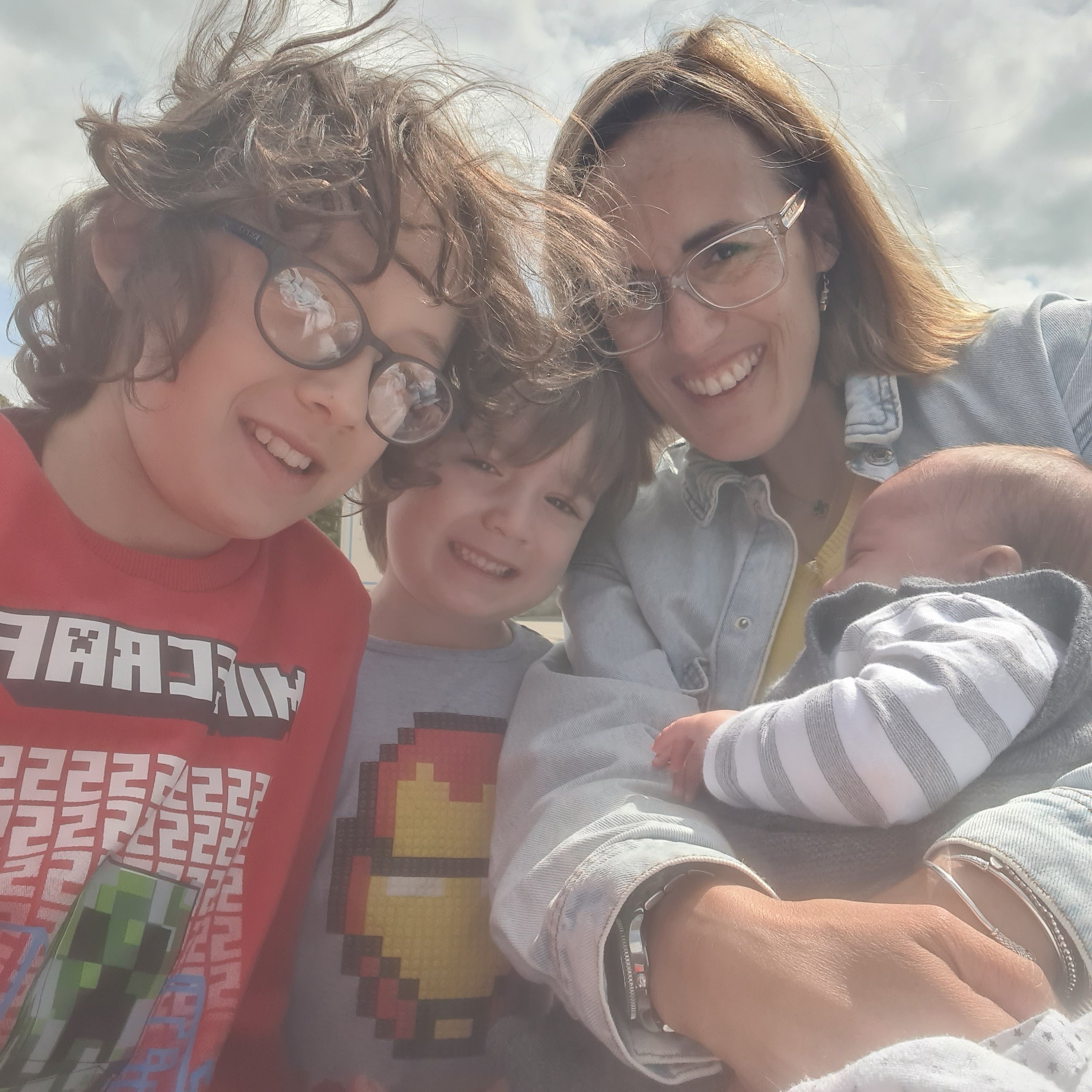 Your Doula Aurelia smiling with her kids, two young boys and a baby