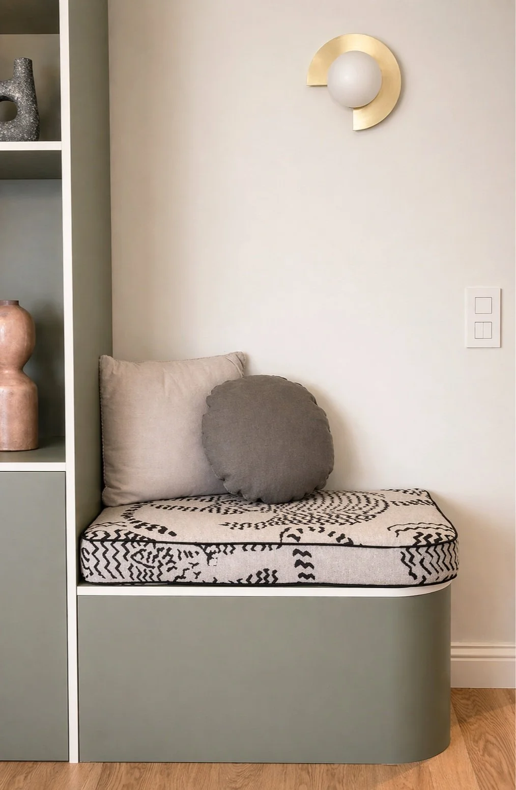 Projet Senillosa à Sarrià – Banquette sur mesure vert sauge avec coussin en tissu graphique noir et blanc et applique murale en laiton, rénovation appartement Barcelone signé Valla & Long Interior Design