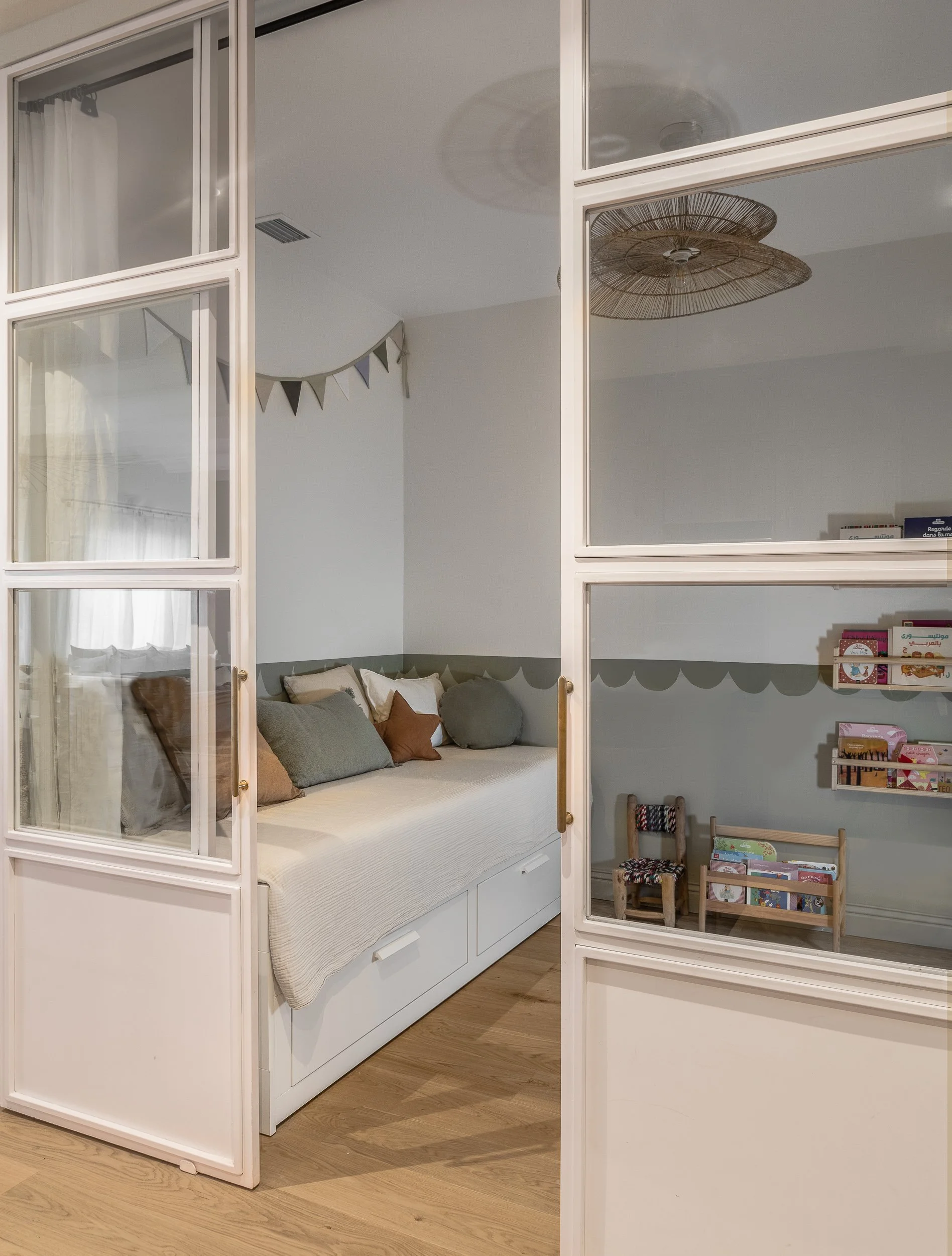 Salle de jeux lumineuse avec verrière sur-mesure dans un appartement familial rénové à Sarrià, Barcelone par Valla & Long Interior Design