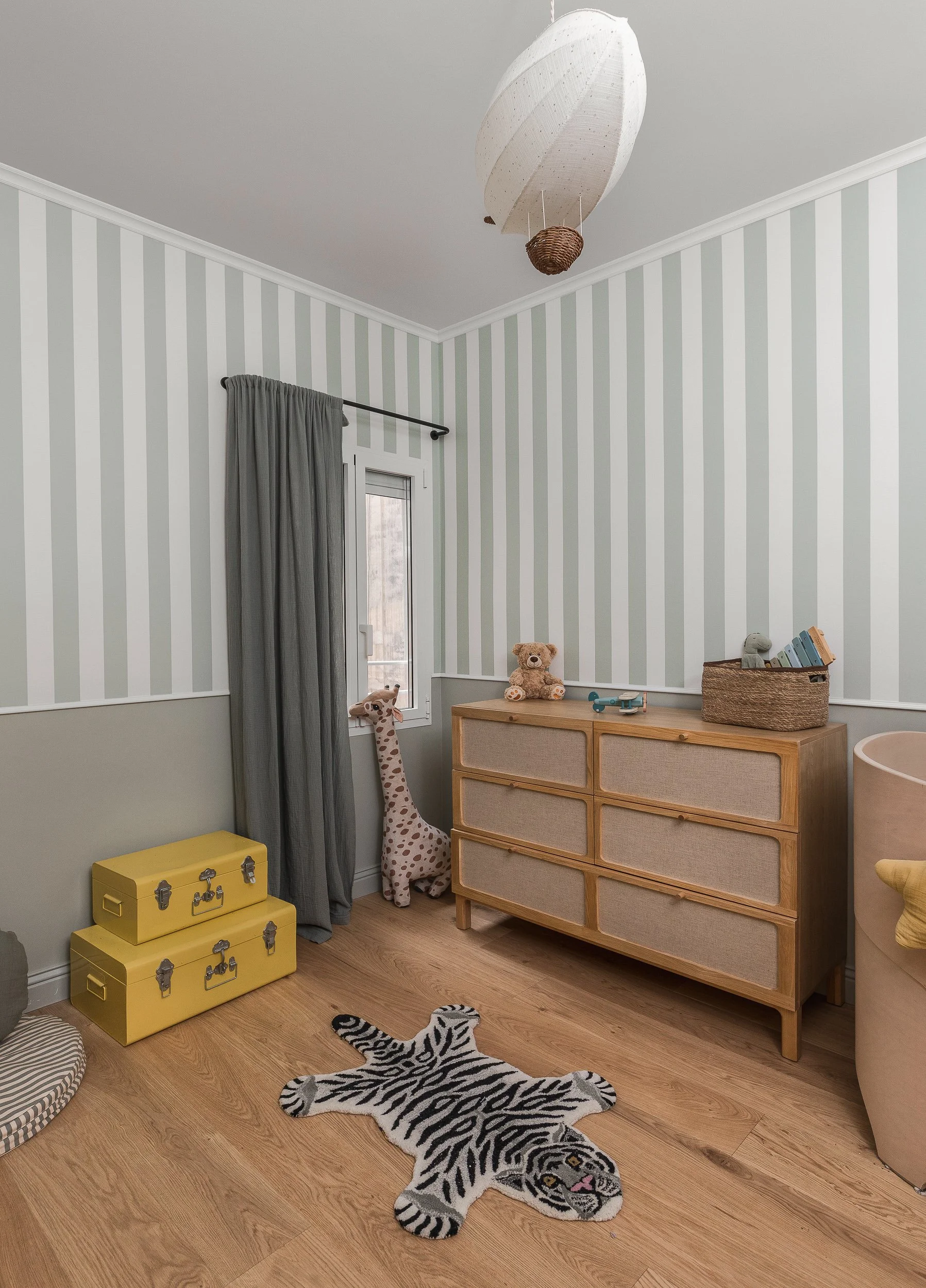 Projet Senillosa à Sarrià – Chambre bébé avec papier peint rayé vert sauge et mobilier en bois naturel, architecte intérieur Barcelone réalisé par Valla & Long Interior Design