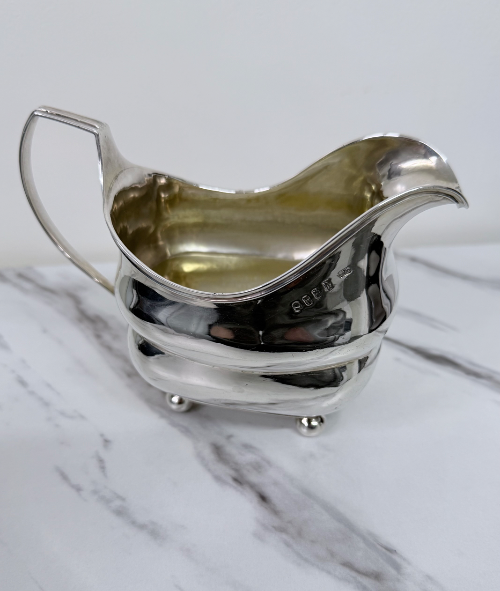 Elegant George III Irish sterling silver sauce boat of rectangular form on ball feet, by William Doyle, Dublin 1808.