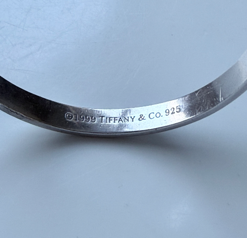 Genuine Tiffany & Co. sterling silver bangle bracelet with classic “1837” and Tiffany marks.
Comes with original pouch/box elements.