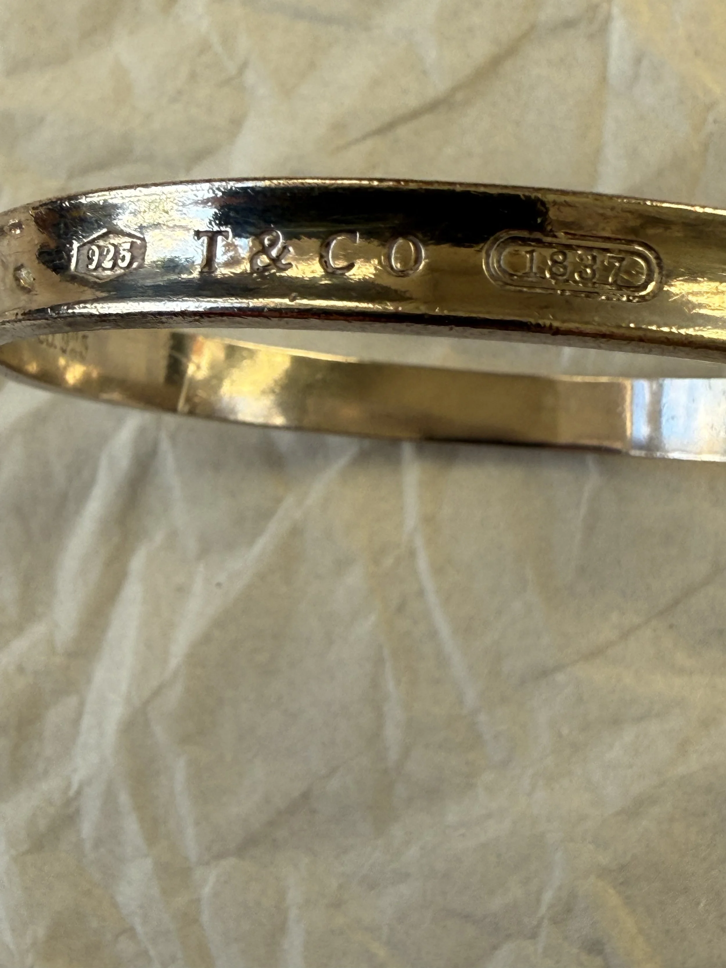 Tiffany bracelet '925', 'T & CO', and 'G883D'.