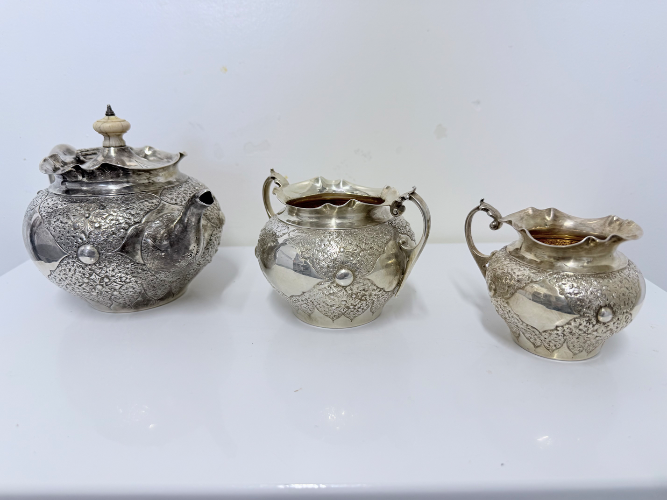 Ornate three-piece Victorian embossed silver bachelor’s tea set by Charles Edwards, London 1880.