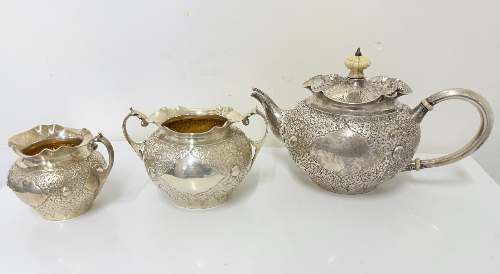 Ornate three-piece Victorian embossed silver bachelor’s tea set by Charles Edwards, London 1880.