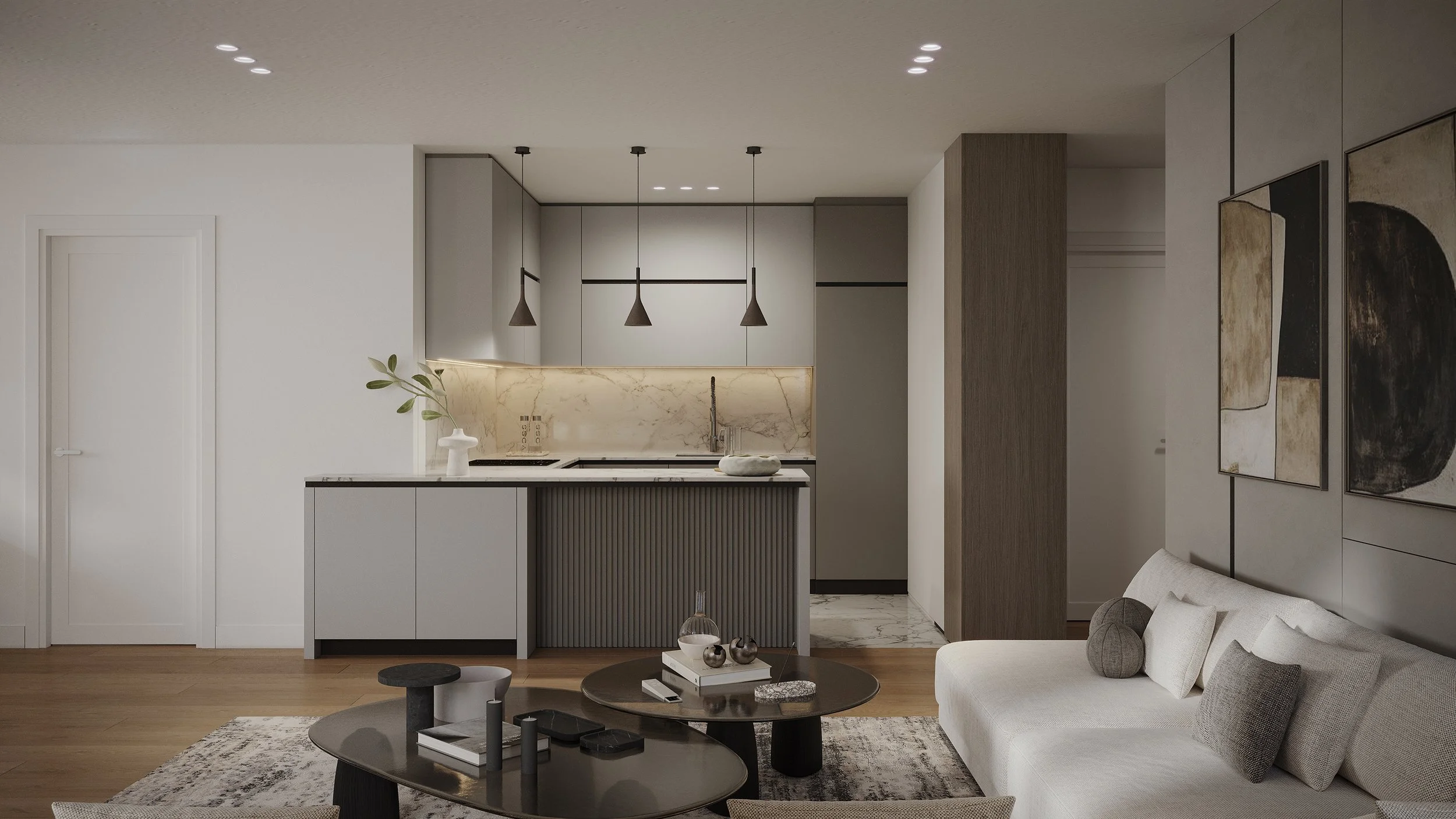 Modern living room with an open kitchen, light-colored sofa, and black coffee table with decorative objects, wall art, and wooden flooring.