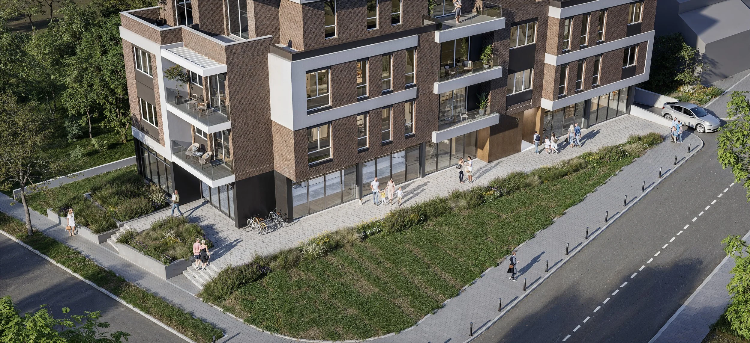A modern multi-story residential building with large glass windows and balconies, surrounded by a landscaped walkway and green areas. People are walking along the sidewalk, some with bicycles parked outside.