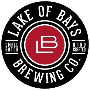 Logo of Lake of Bays Brewing Co. featuring a black circular design with white text, a red center with white initials 'LB,' and additional wording indicating small batch and hand-crafted brewing.