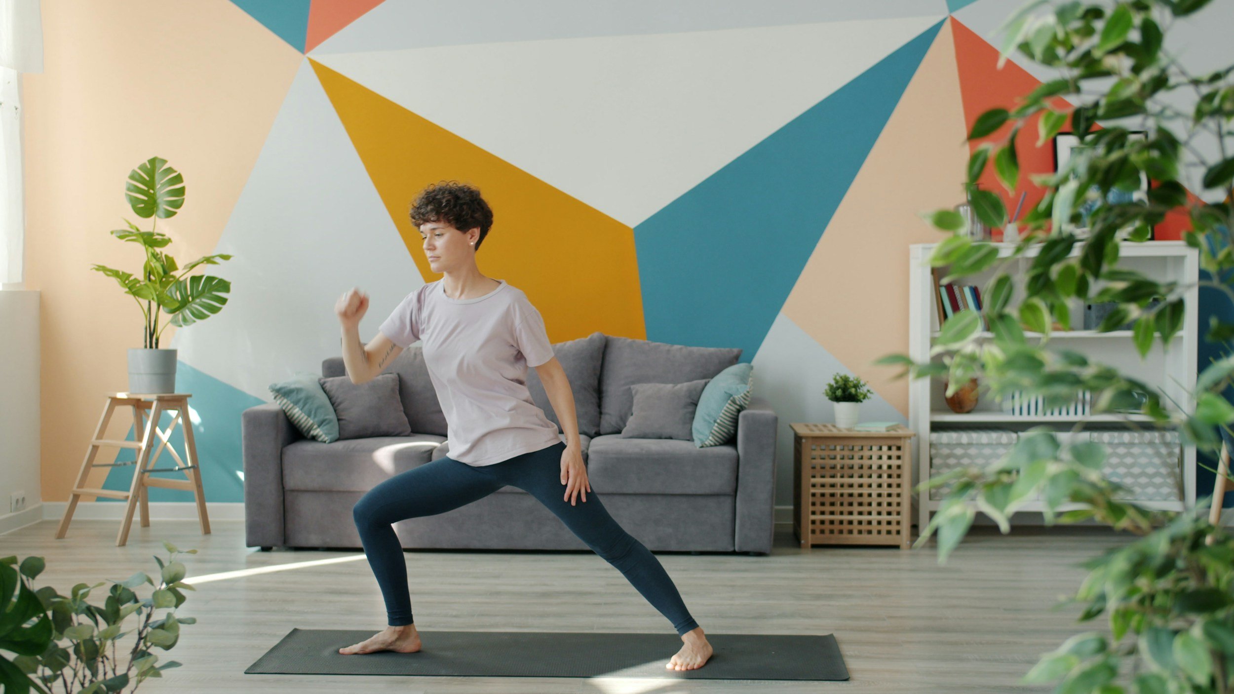 A woman performing prescriptive mobility exercises in her living room as part of a LifeFit mobile clinical-adjacent fitness consultation in Suffolk County.