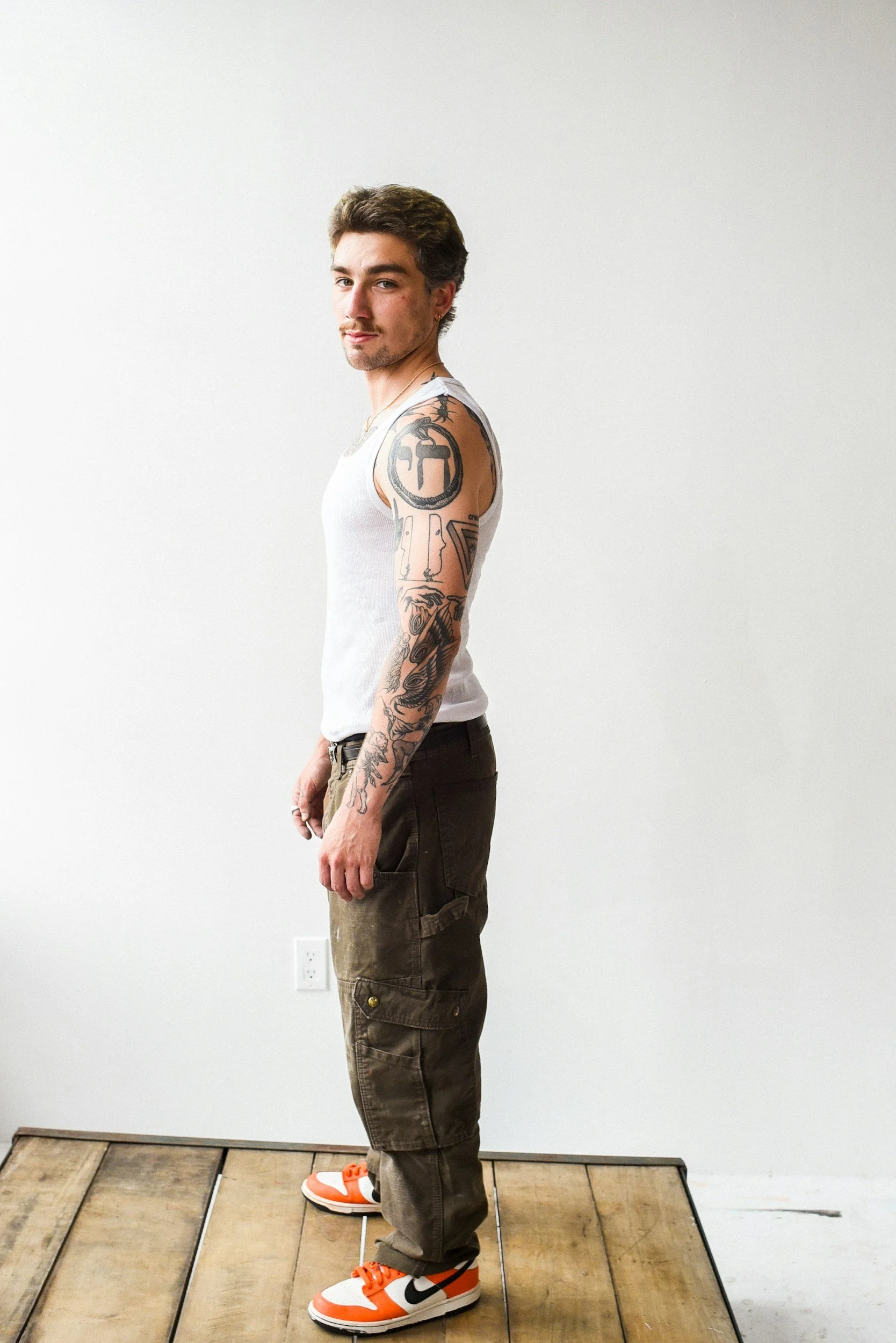 A man demonstrating the 'digital slump' side-by-side with correct posture, showing ears stacked over shoulders to reverse tech neck and spinal stress.