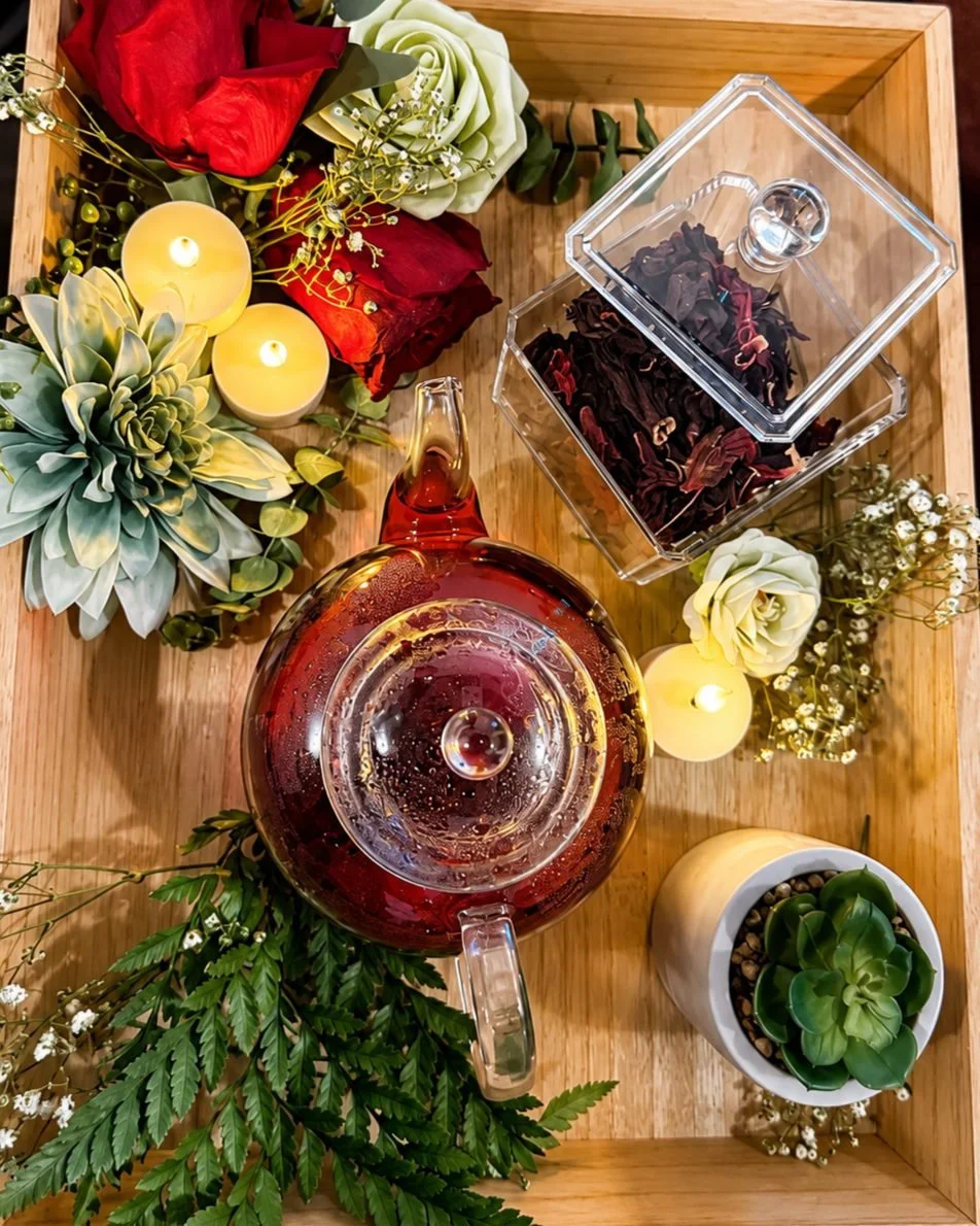 Glass teapot, flowers and candles set up for the Royal Radiant Ritual