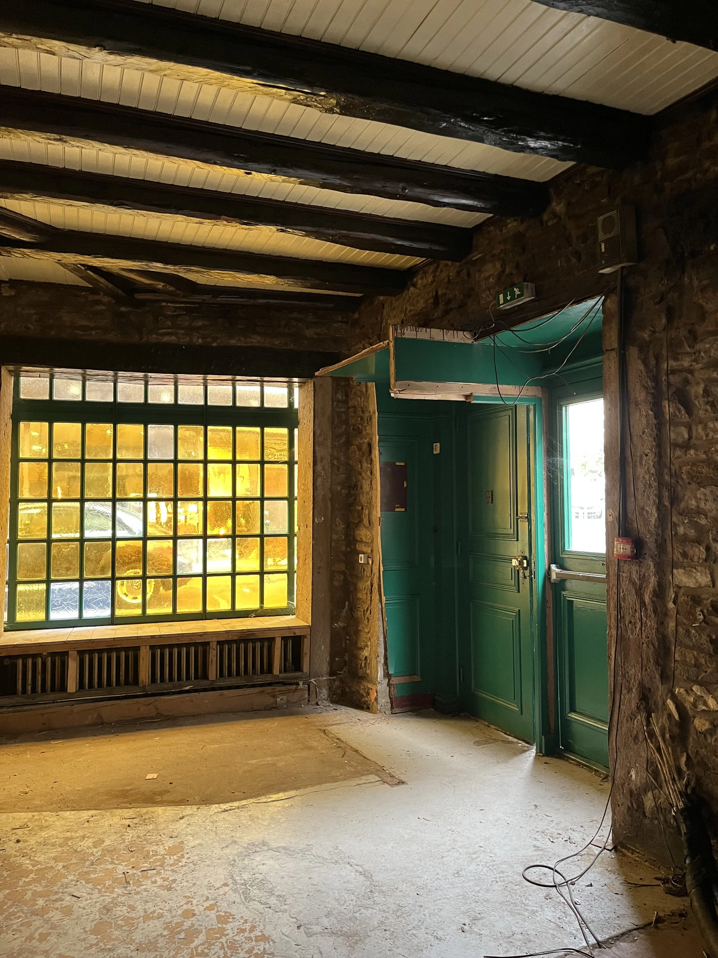 Intérieur en cours de rénovation avec murs en pierre et structure bois apparente, projet de transformation et rénovation intérieure pour particuliers ou professionnels à Annecy et à distance.