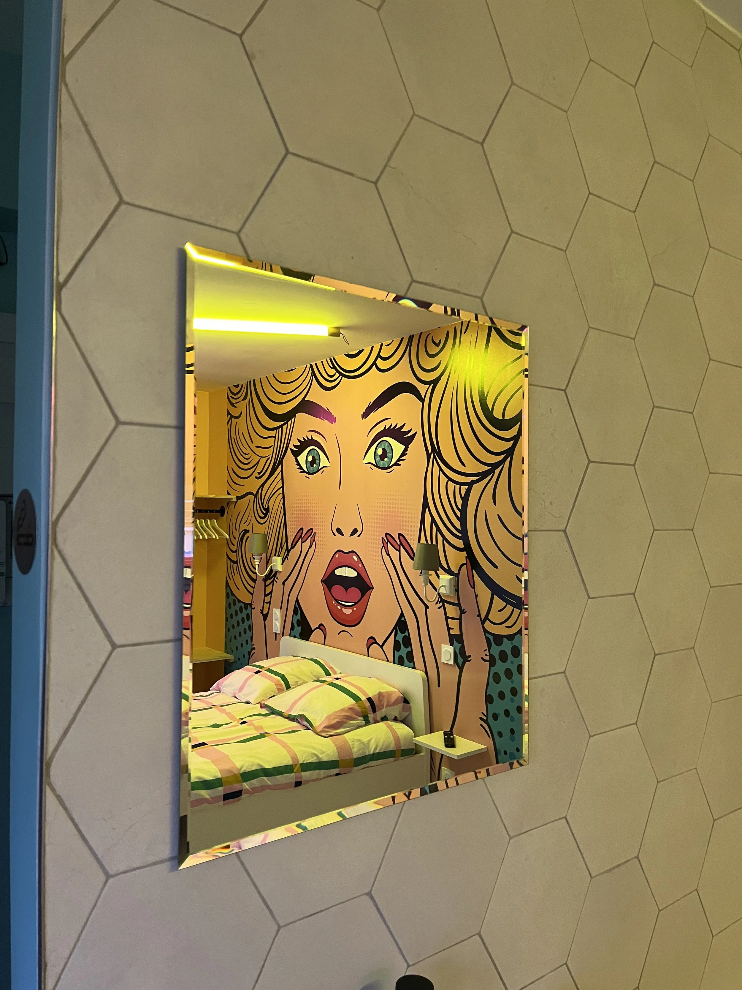 Une chambre décorée avec une fresque murale de style bande dessinée d'une femme avec une expression de surprise.