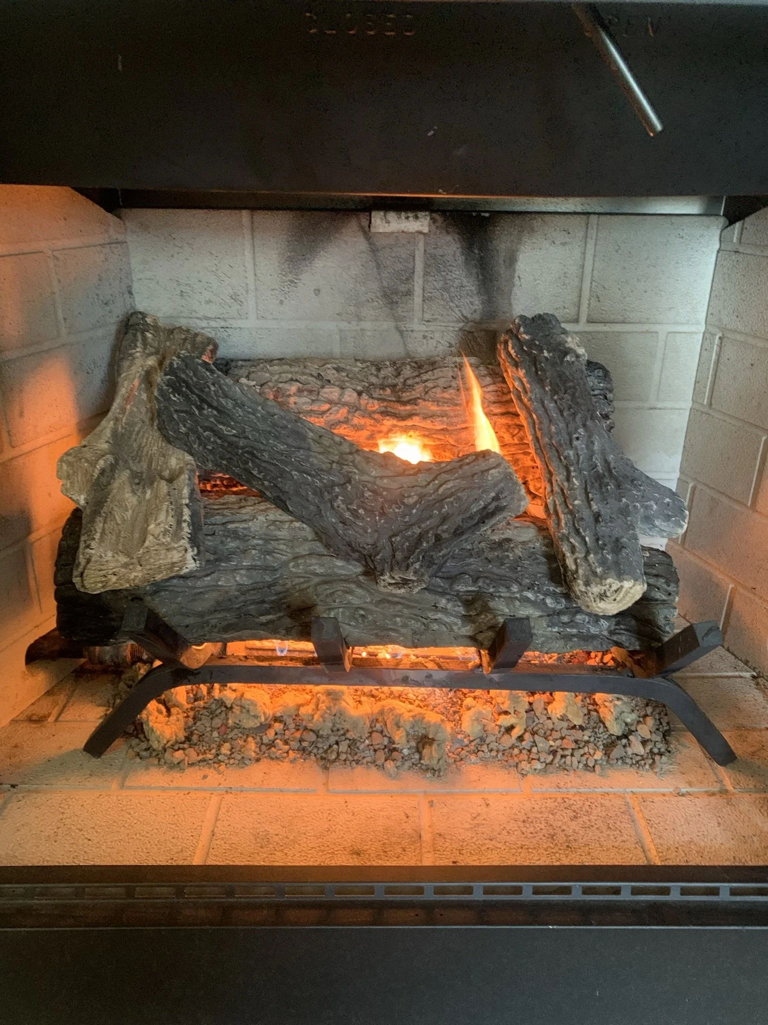 Faux electric fireplace with burning logs and glowing embers