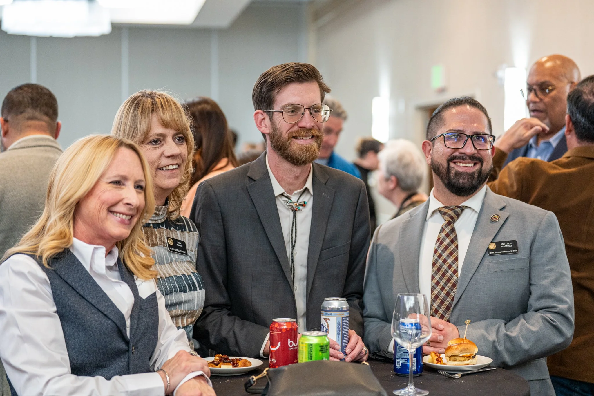 Four people around table smiling with drinks
