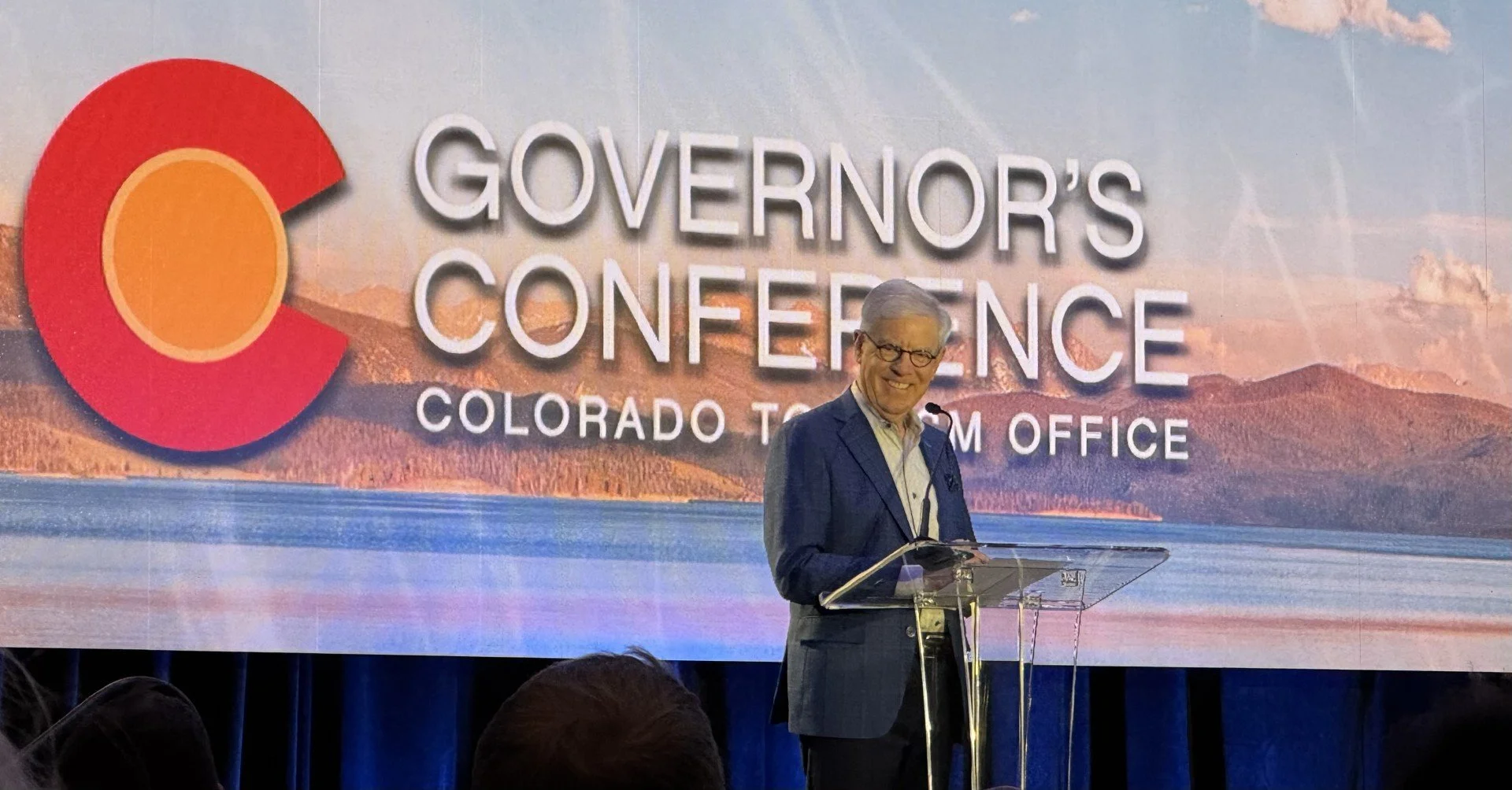 man standing at podium talking