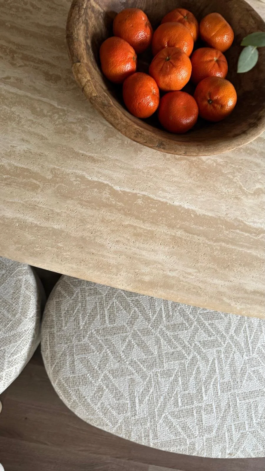 Een houten schaal met mandarijnen als styling-detail in een warm interieur