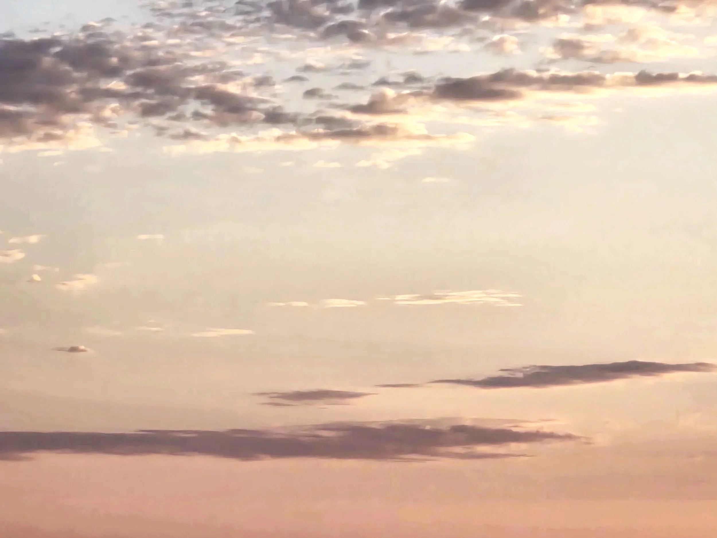 Sky with scattered clouds during sunset, showing a gradient of soft pastel colors.