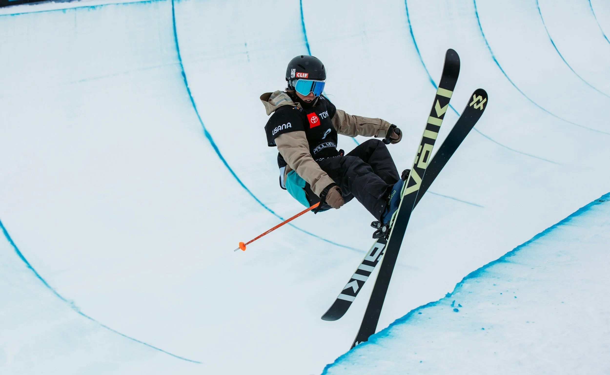 Free-style skier in a half-pipe, jumping off the right hand side wall of the half-pipe