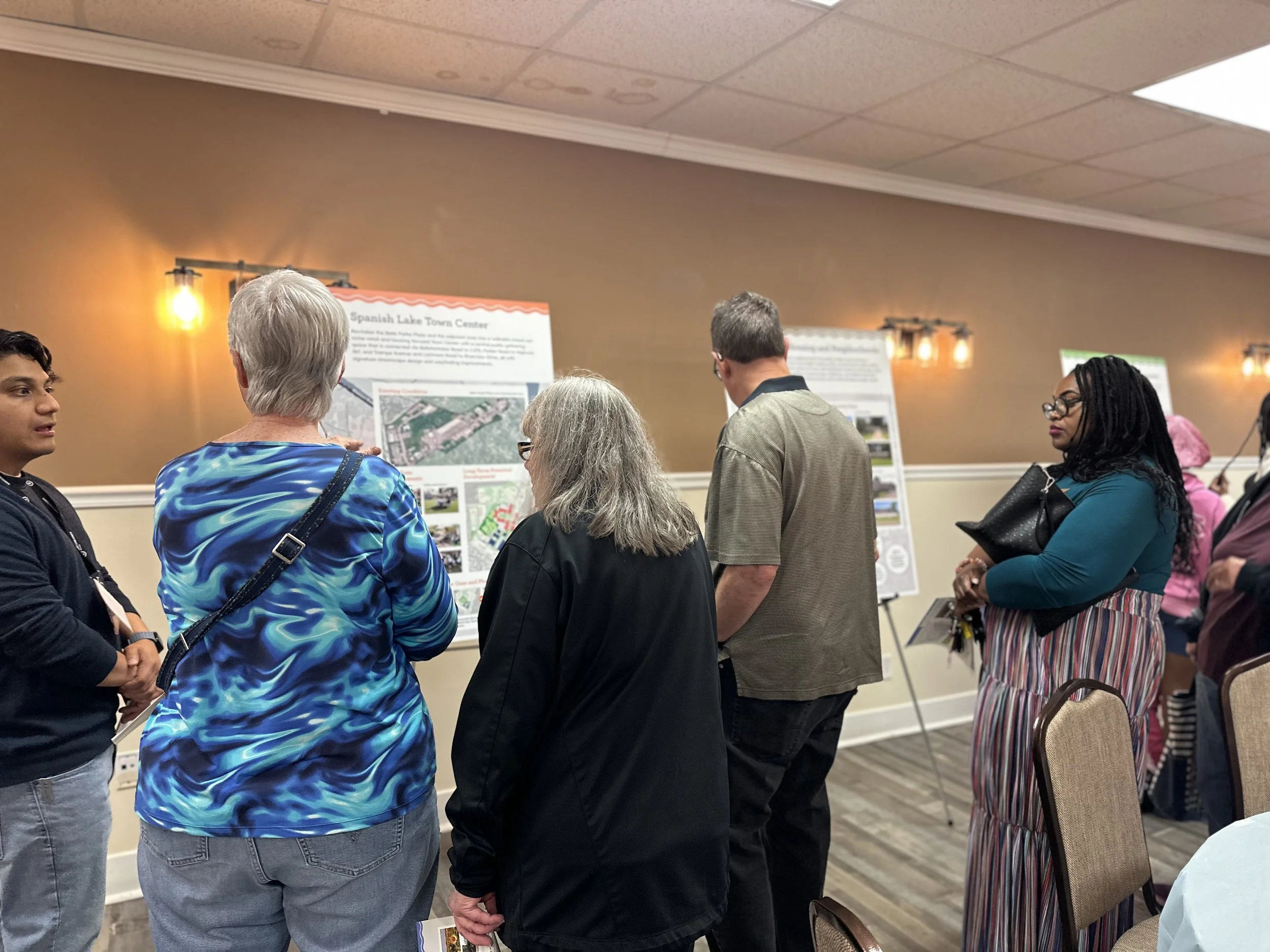 Attendees of an open house looking at project boards