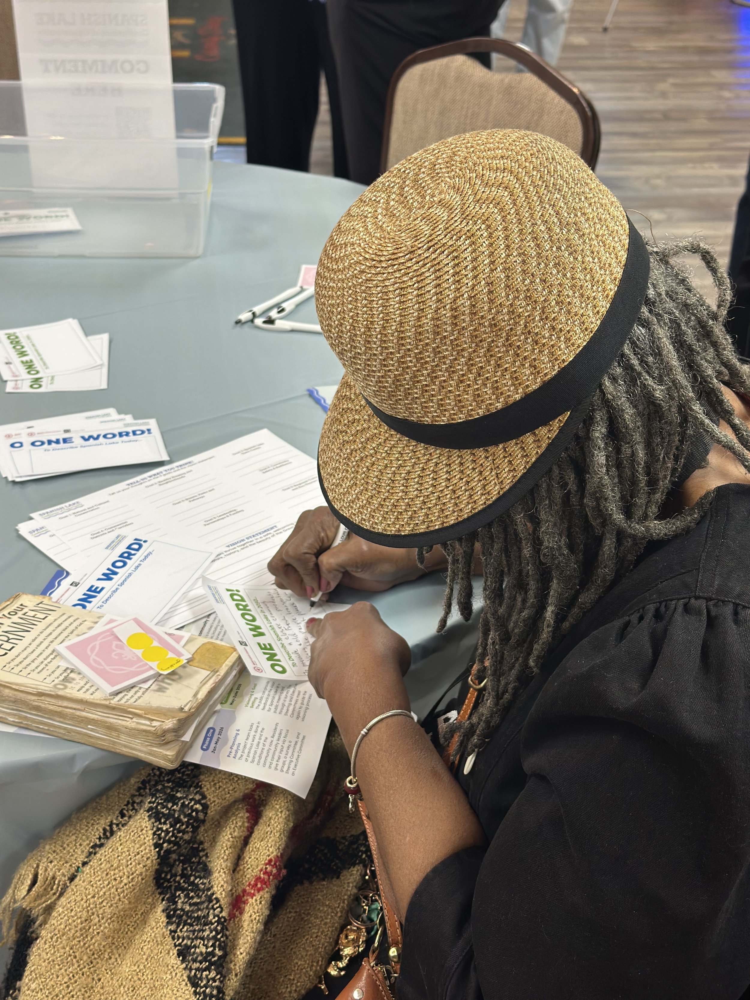 A participant at the first Open House writes on a comment form