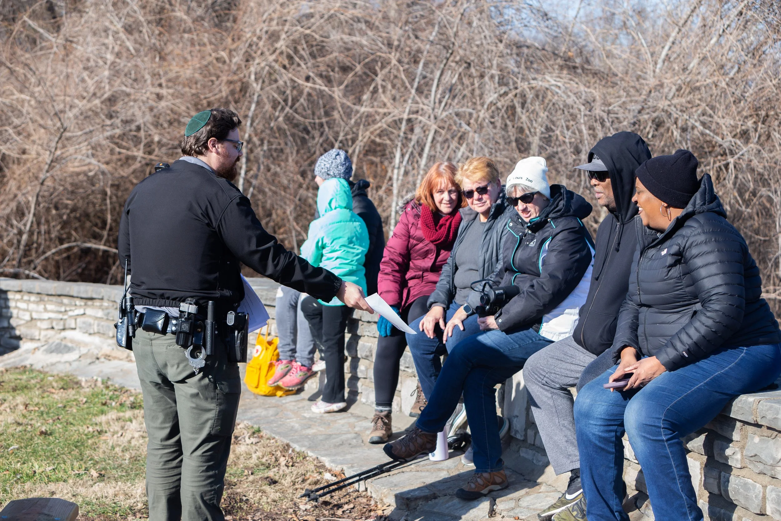 A group of people receive information from a park ranger about bald eagle watching at Fort Bellefontaine