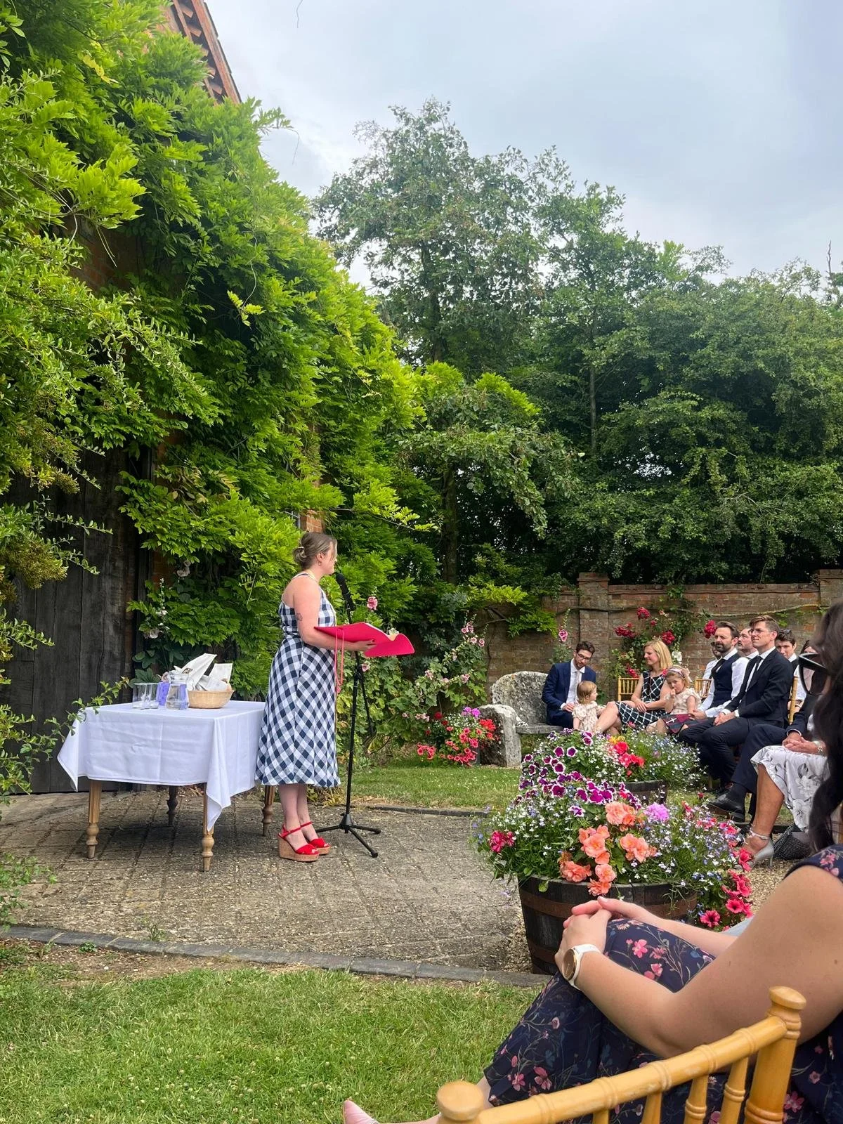 A wedding celebrant standing up with a folder in her hands in front of an audience