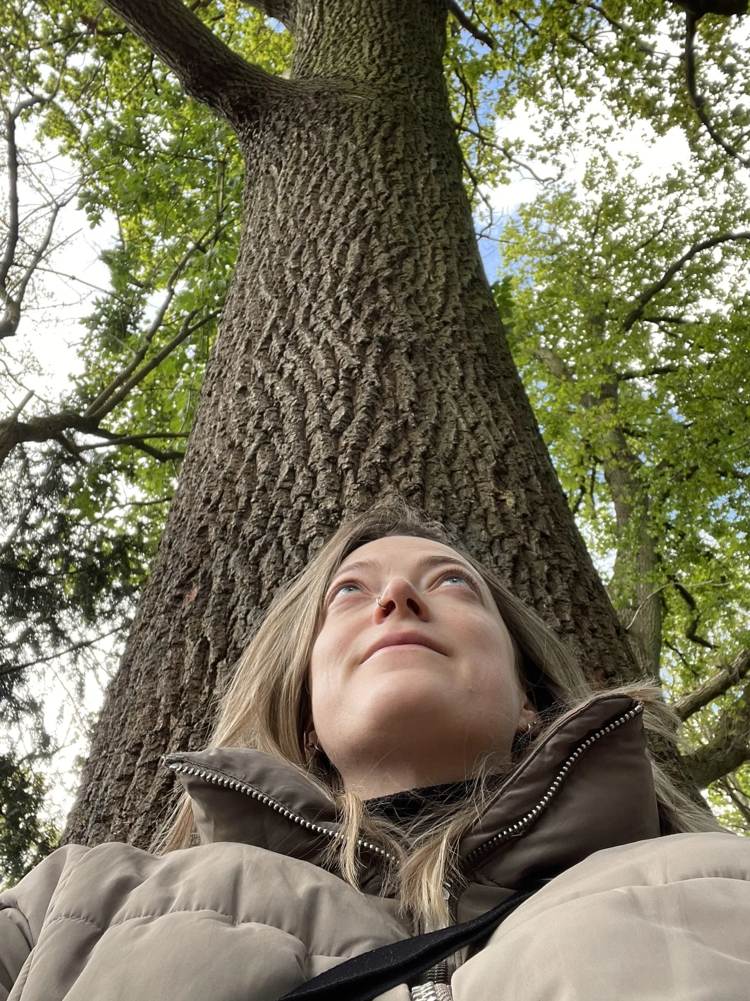 Interfaith minister Rev Holly's face and shoulders as she sits with her back against a tree