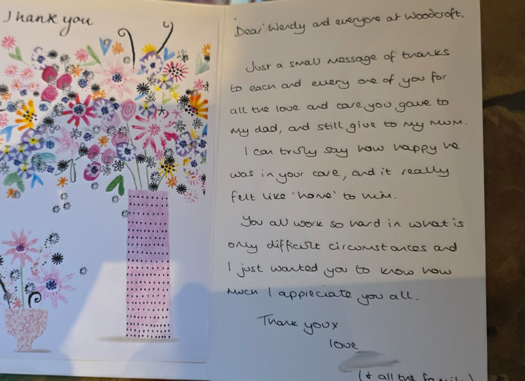 A thank you card with colorful floral illustrations and a pink polka dot ribbon, containing a handwritten message to 'Wendy and everyone at Woodcroft' expressing gratitude and appreciation.