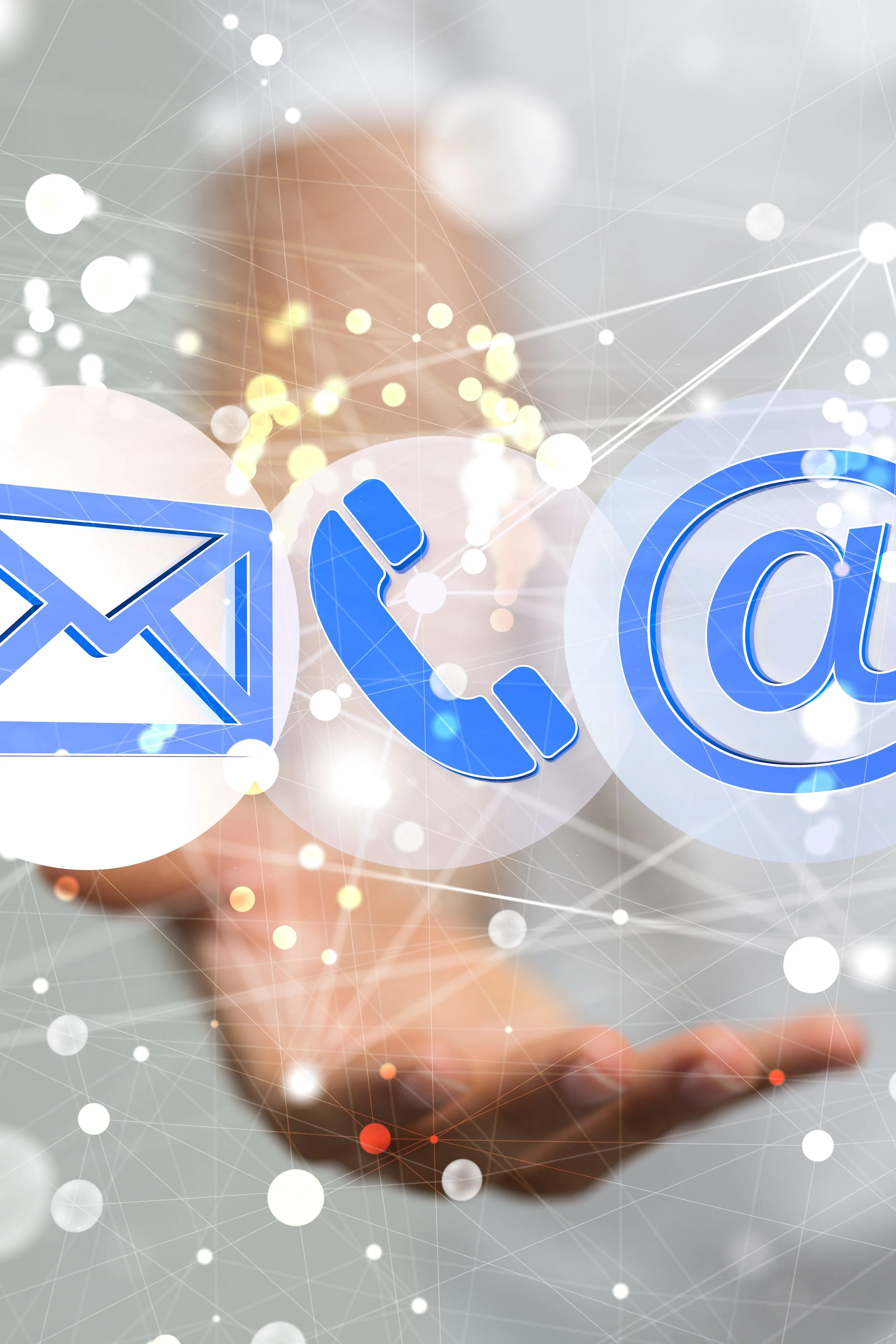 Digital icons of an envelope, phone receiver, and at symbol floating above a person's hand, representing communication and email technology.