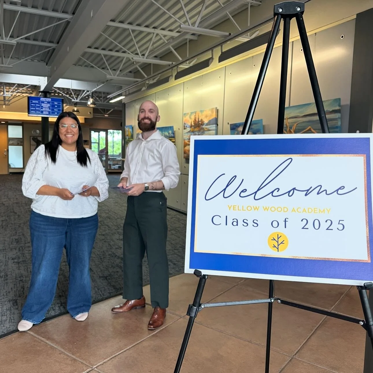 Yellow Wood Academy staff standing beside a Class of 2025 graduation welcome sign