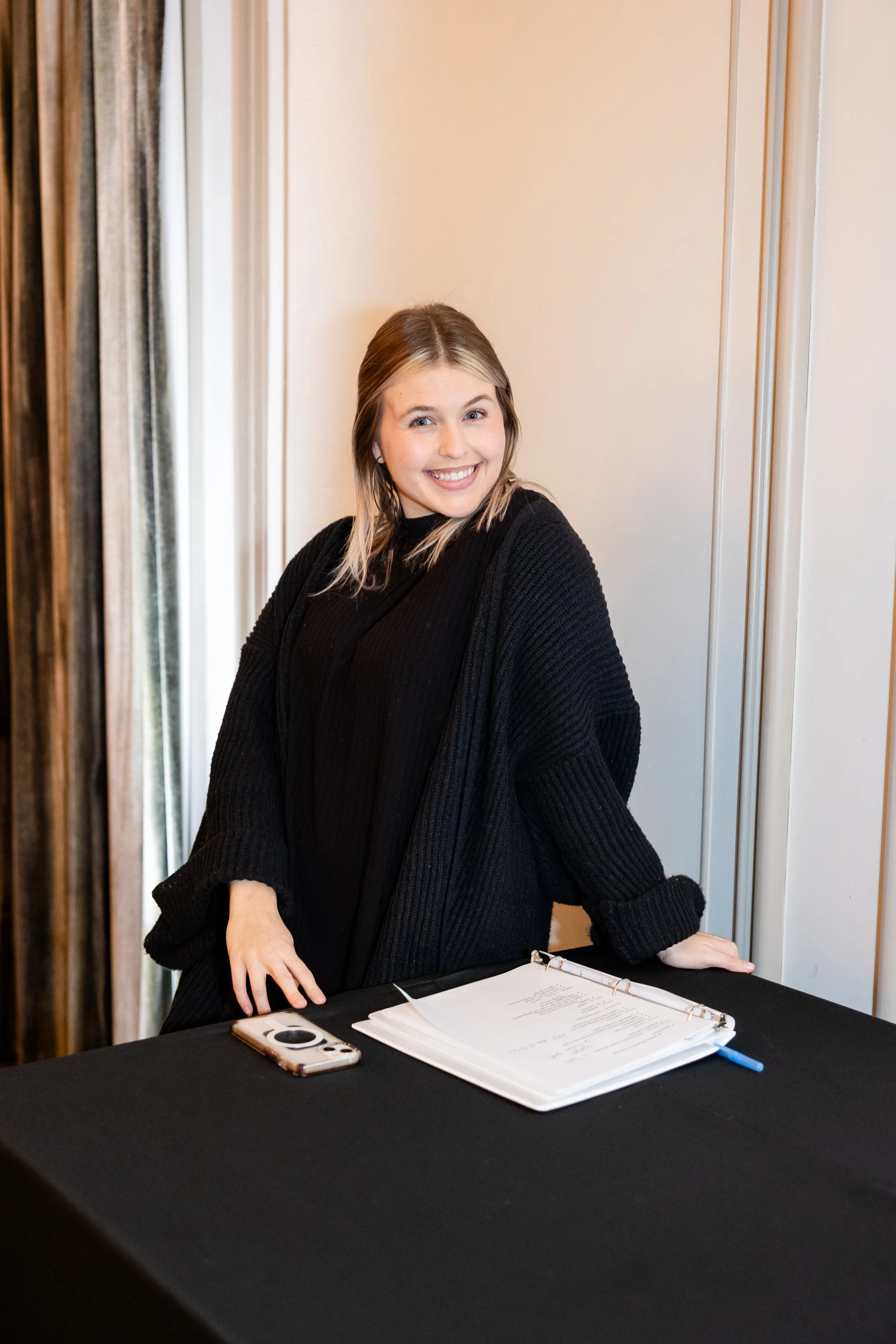 A young woman with blonde hair in a black sweater leading the wedding party on the Megan Mae Events team. 