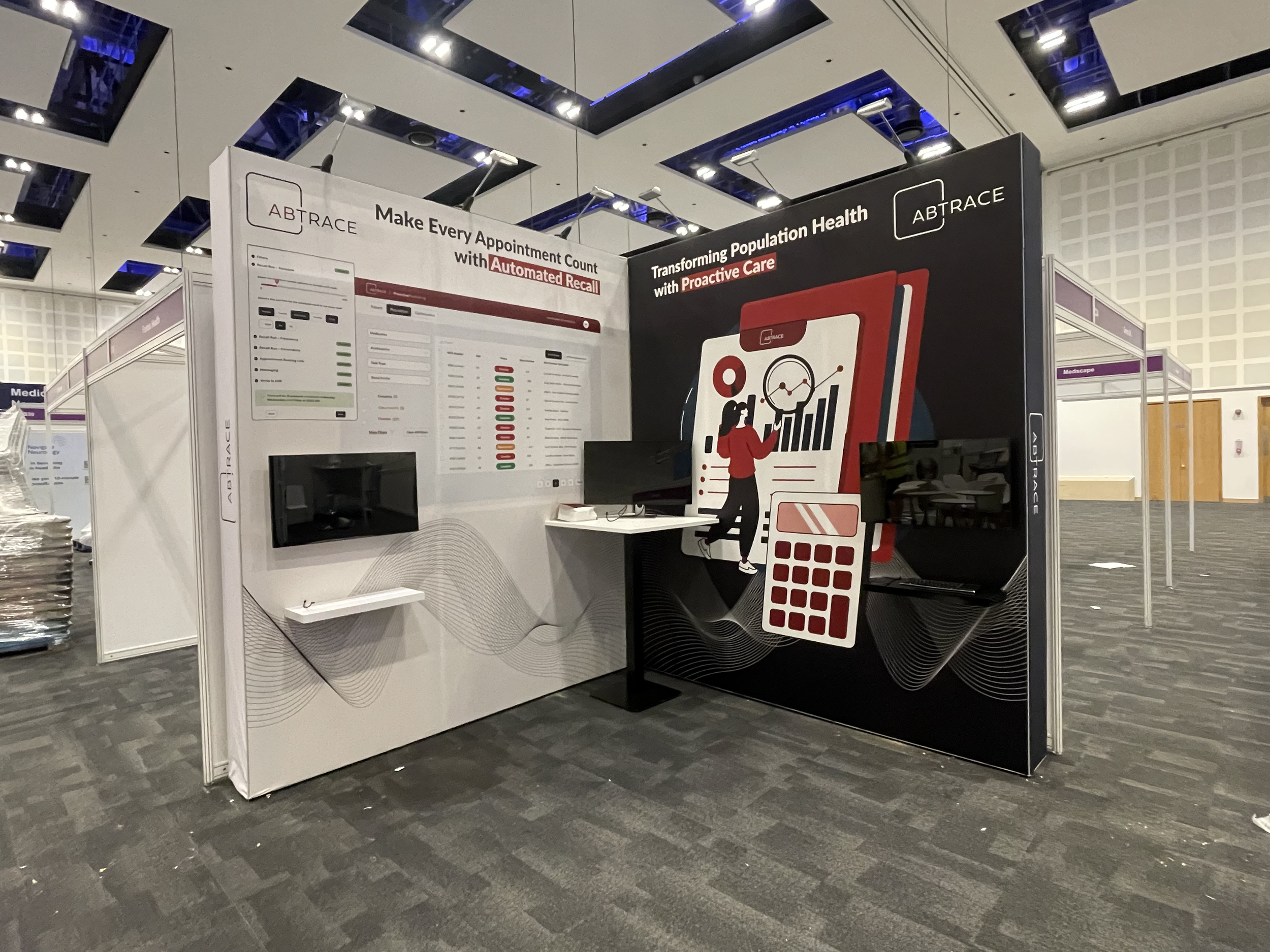 Exhibition booth with slogans about healthcare and appointment management, featuring visuals of digital health tools, graphs, and computer screens.