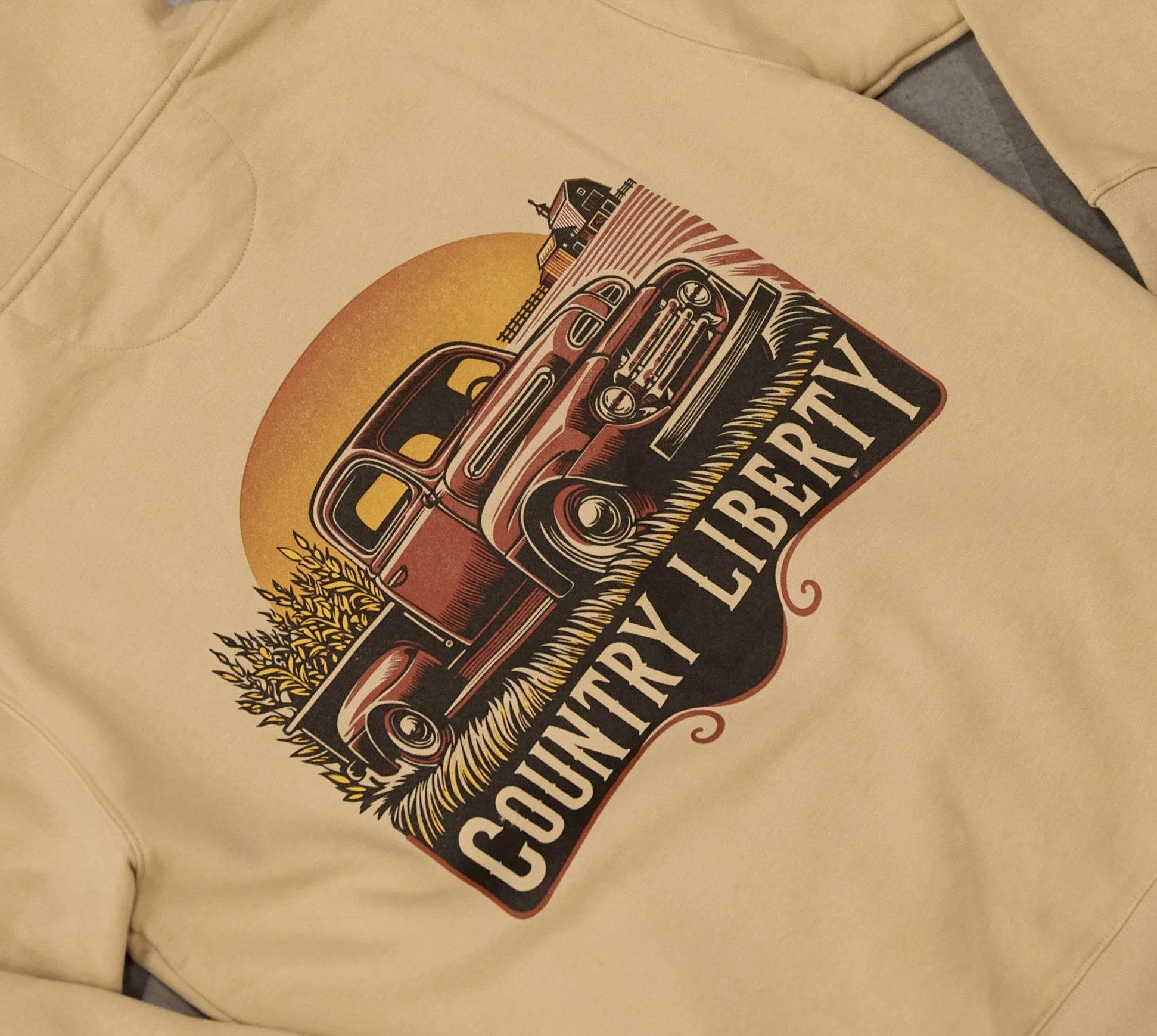A white sweatshirt with a graphic design of a vintage truck, trees, a sun, and the words 'Country Liberty' in a banner style.