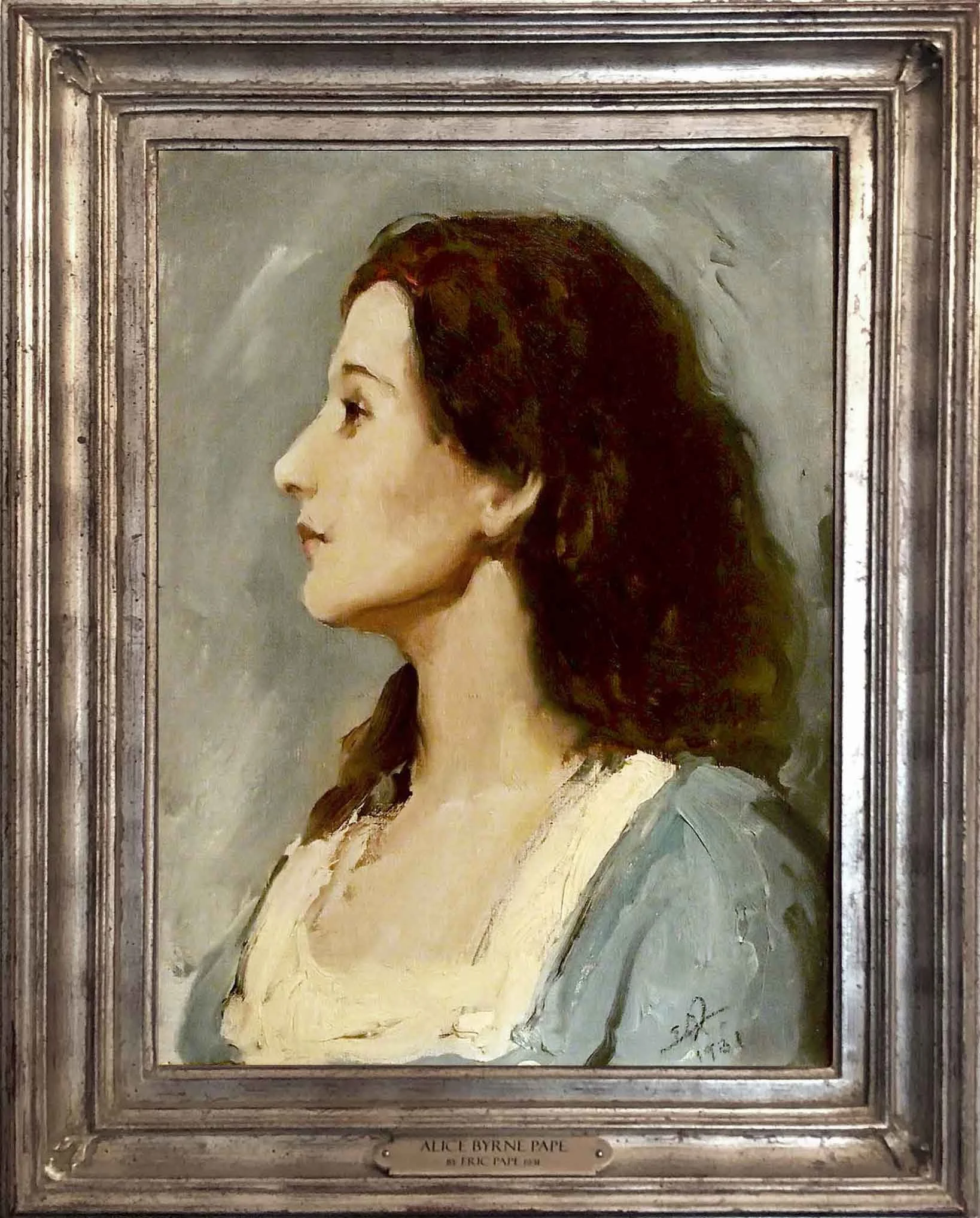A portrait painting of a woman in profile with dark curly hair, wearing a light-colored top, framed in a metallic frame, with a small plaque at the bottom that reads 'Alice Byrne Pape by Eric Pape 1915'.