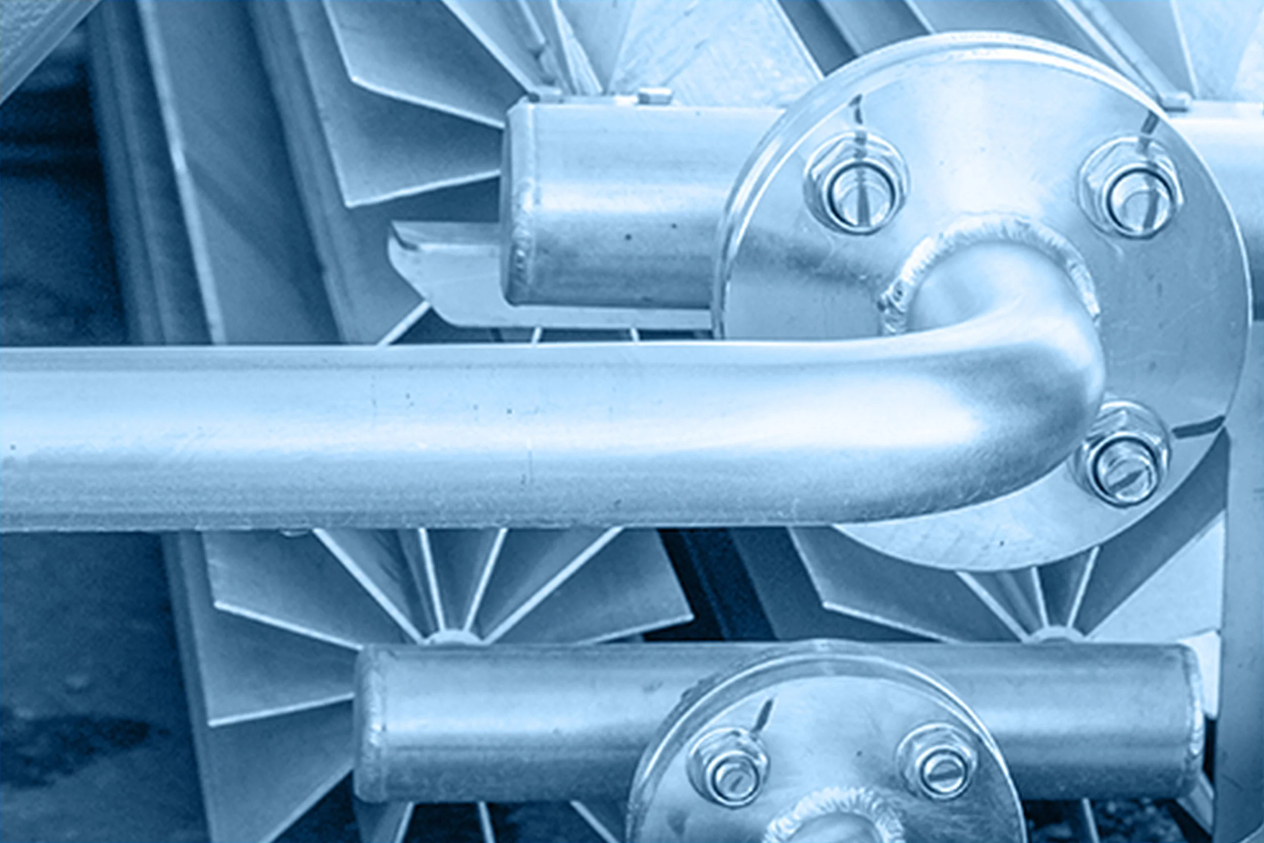 Close-up of a metallic industrial machine or engine component with various bolts, gears, and parts.