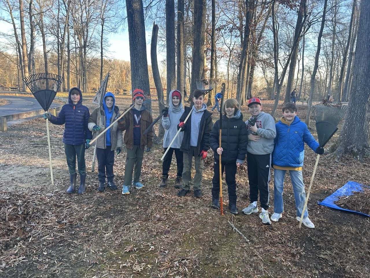 Boy Scouts raking leaves at a park