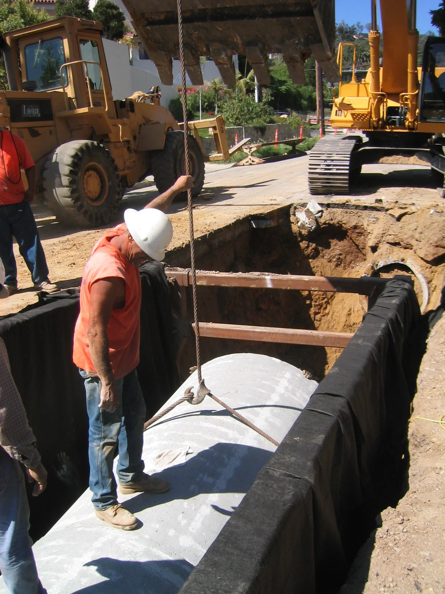Construction workers laying concrete on a construction site with heavy machinery.